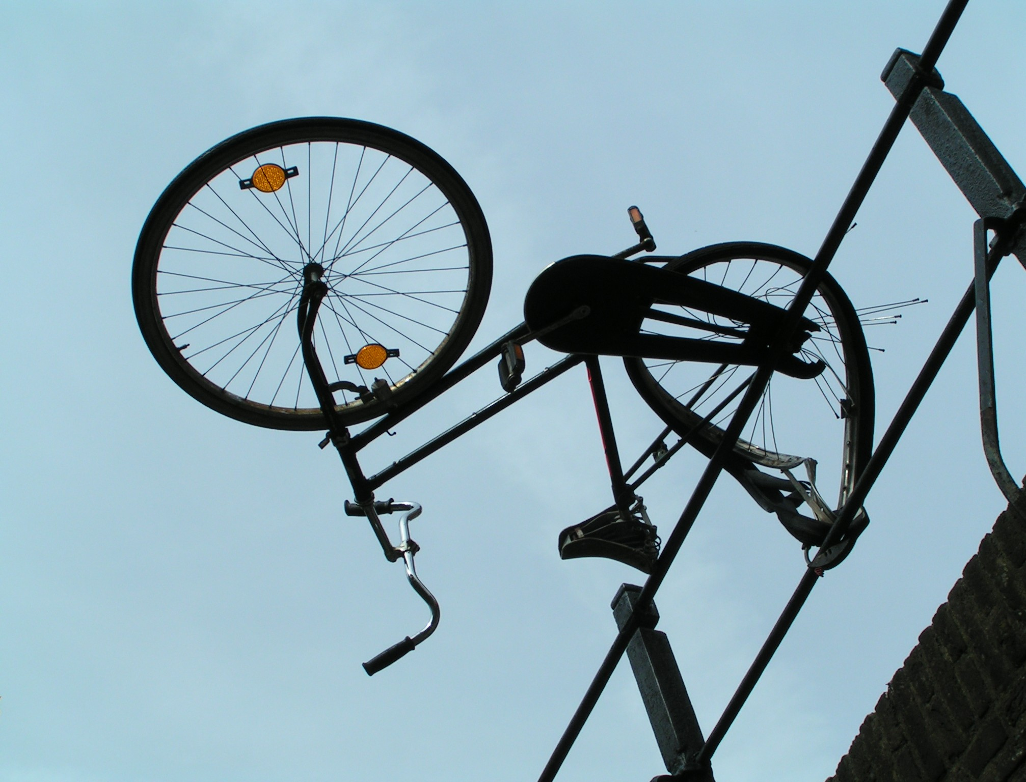 Demoliertes Fahrrad mit Achter kopfüber über ein Geländer gehängt