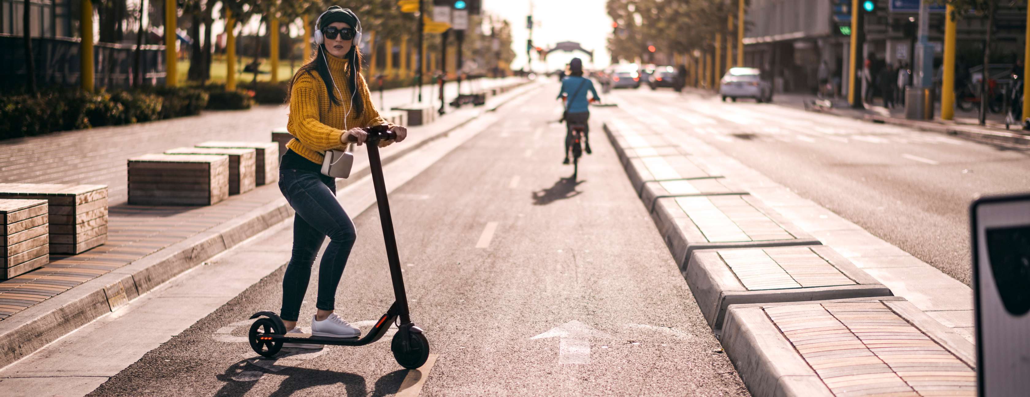 Frau fährt mit Elektro-Scooter auf Radweg