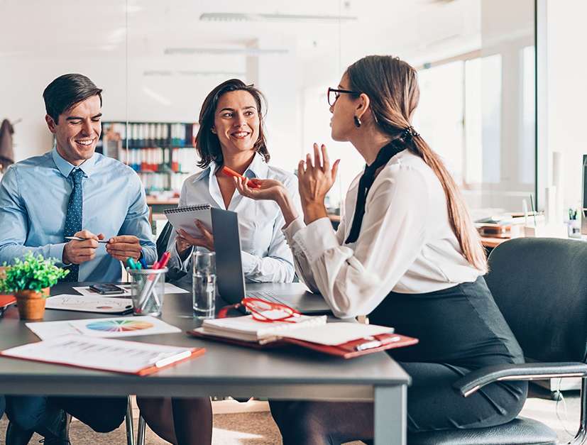Allianz - Straf-Rechtsschutzversicherung: Vier Personen, zwei Männer in Anzügen und zwei Frauen im Business-Outfit, in einem Büro führen ein Gespröch.