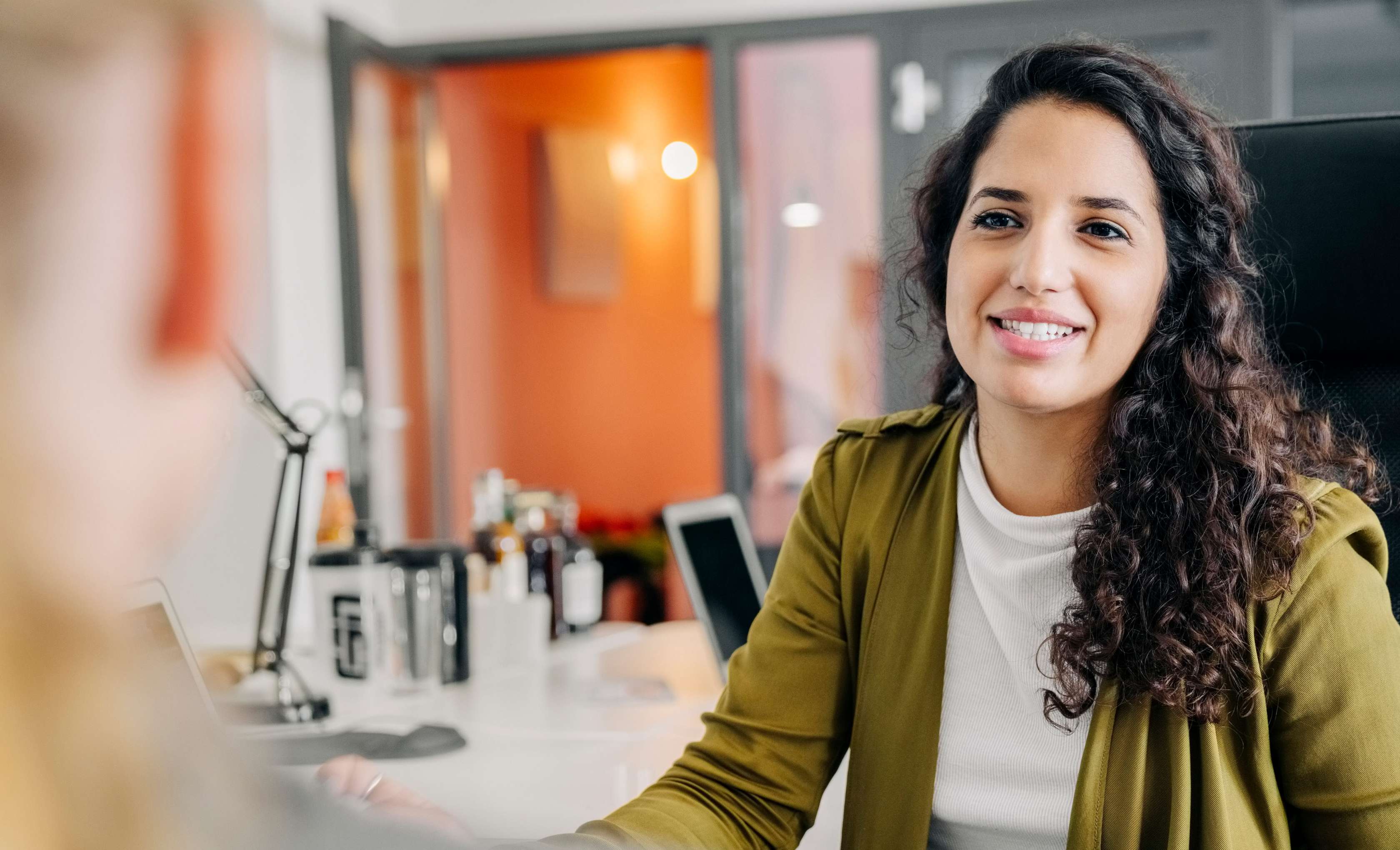 Allianz Private Krankenversicherung für Beamte und Beamtinnen: Eine Frau sitzt jemandem gegenüber und unterhält sich über Tarife.