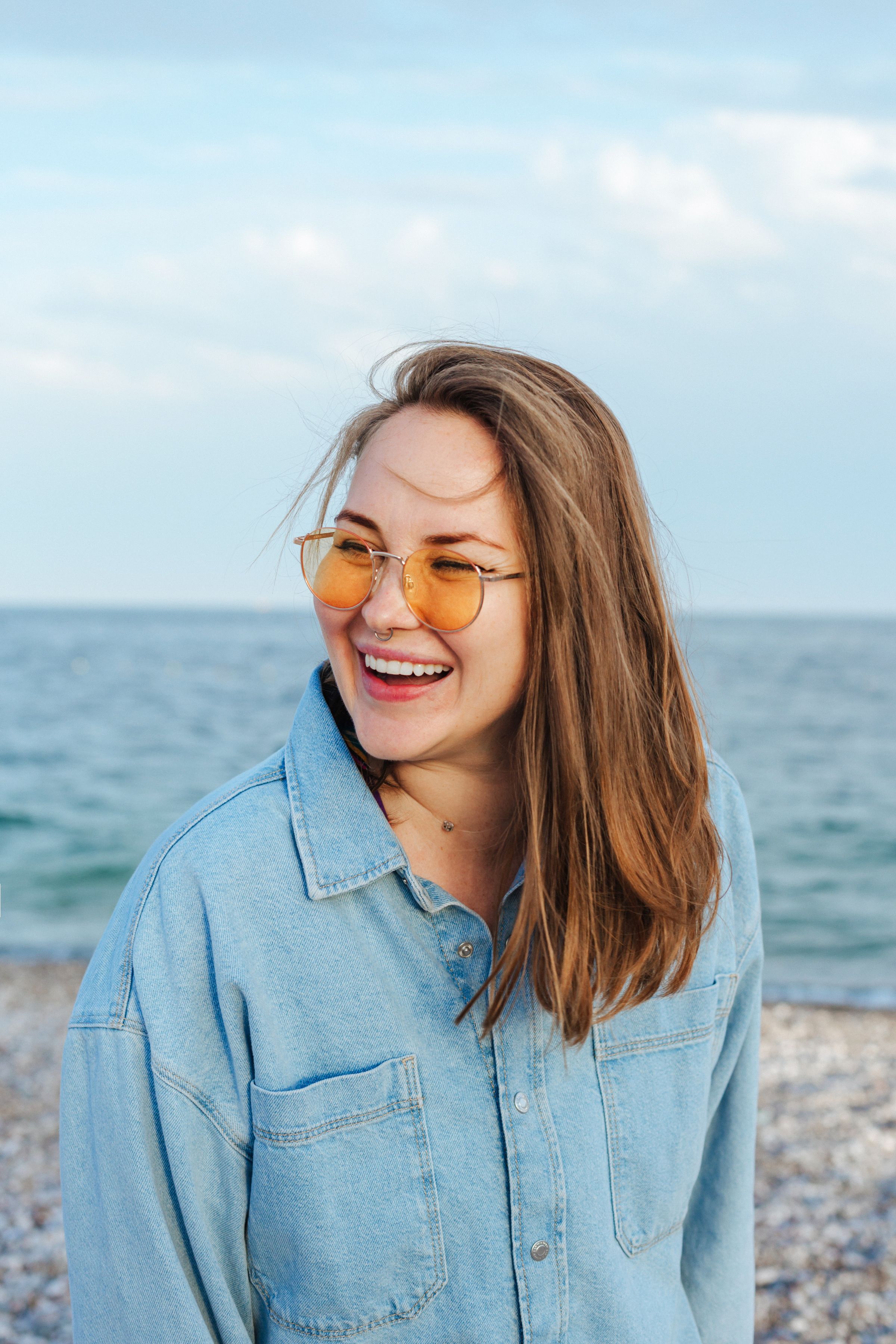 Frau mit Brille lächelnd am Strand