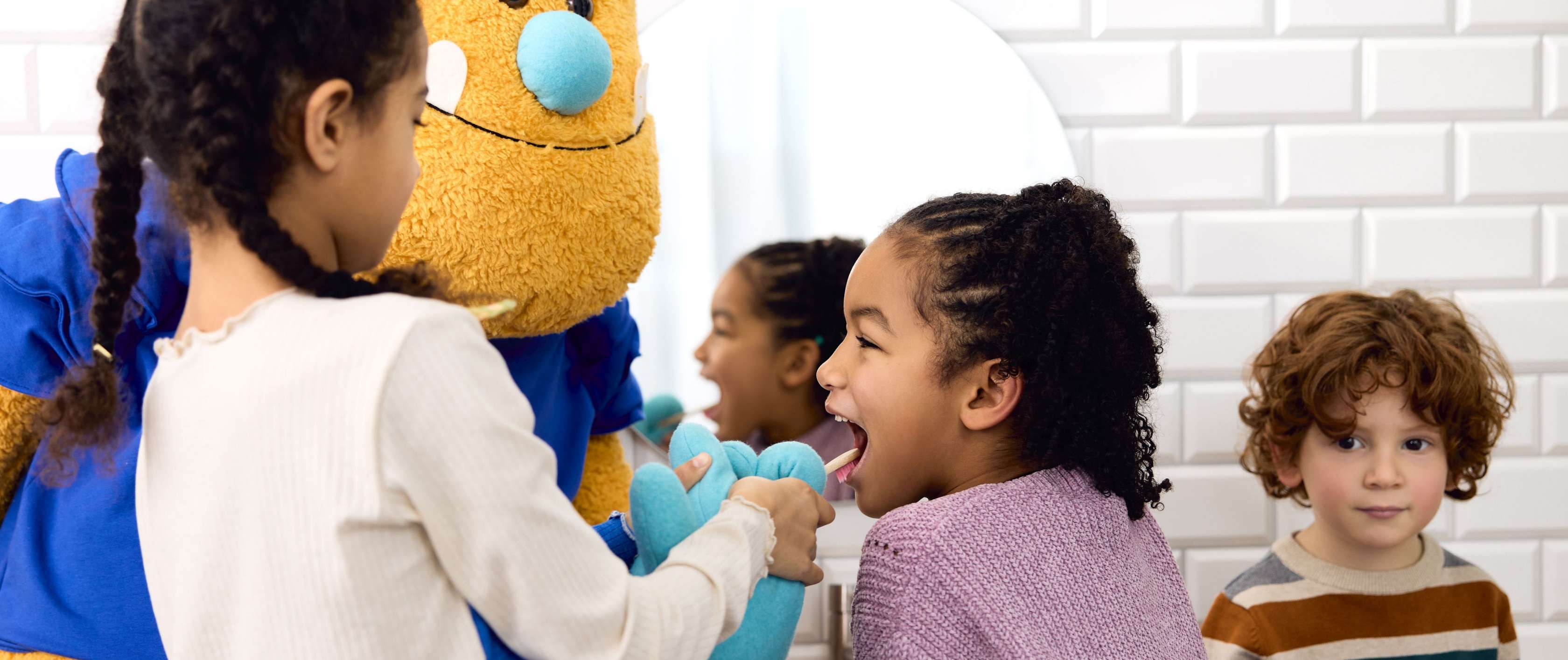 Kinder spielen mit einem großen Plüsch-Monster.