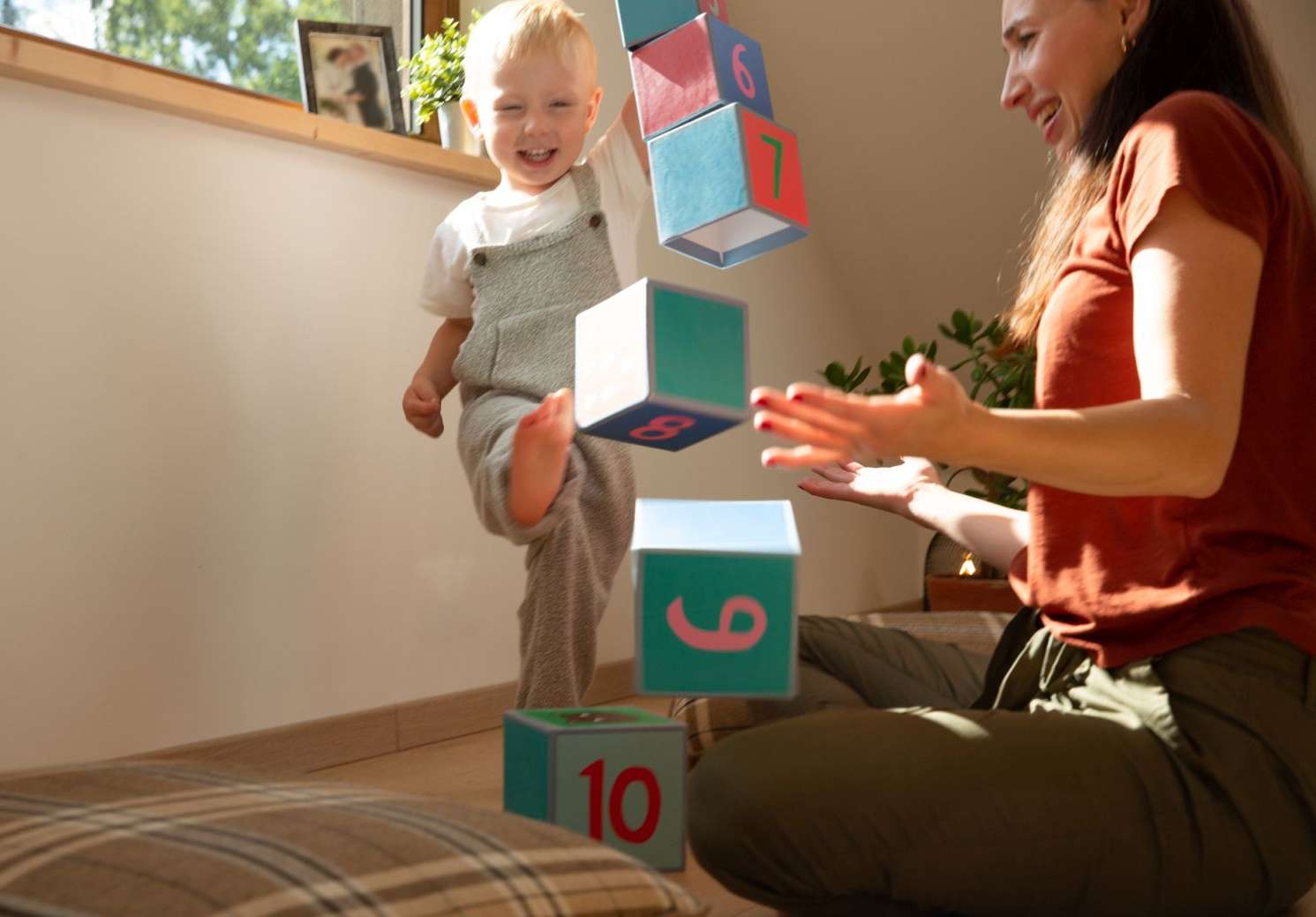 Allianz Versicherungen für Kinder: Kind tritt einen Turm mit Spielzeugwürfeln um