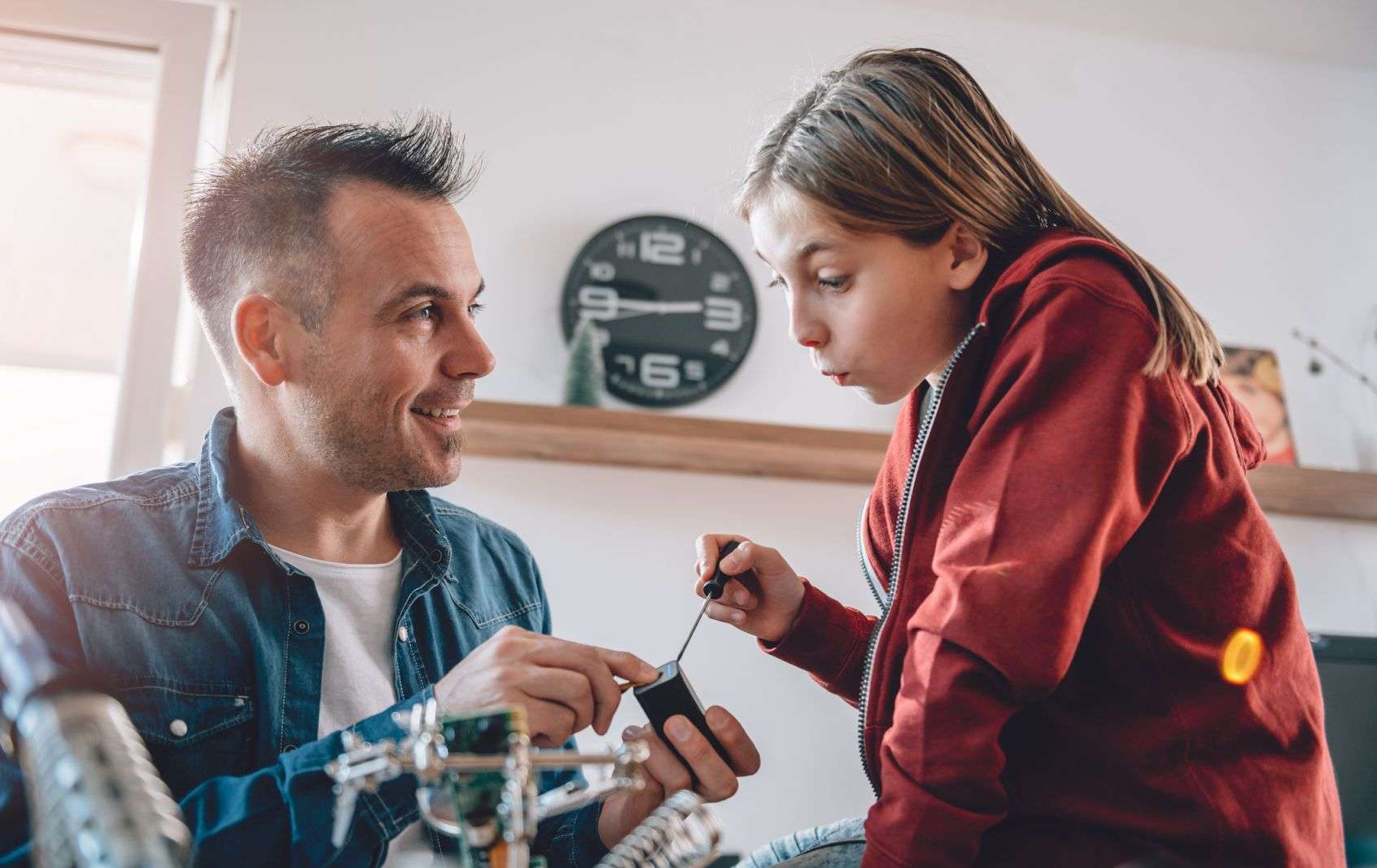 Allianz Versicherungen für Jugend­liche: Vater und Tochter beim gemeinsamen Basteln