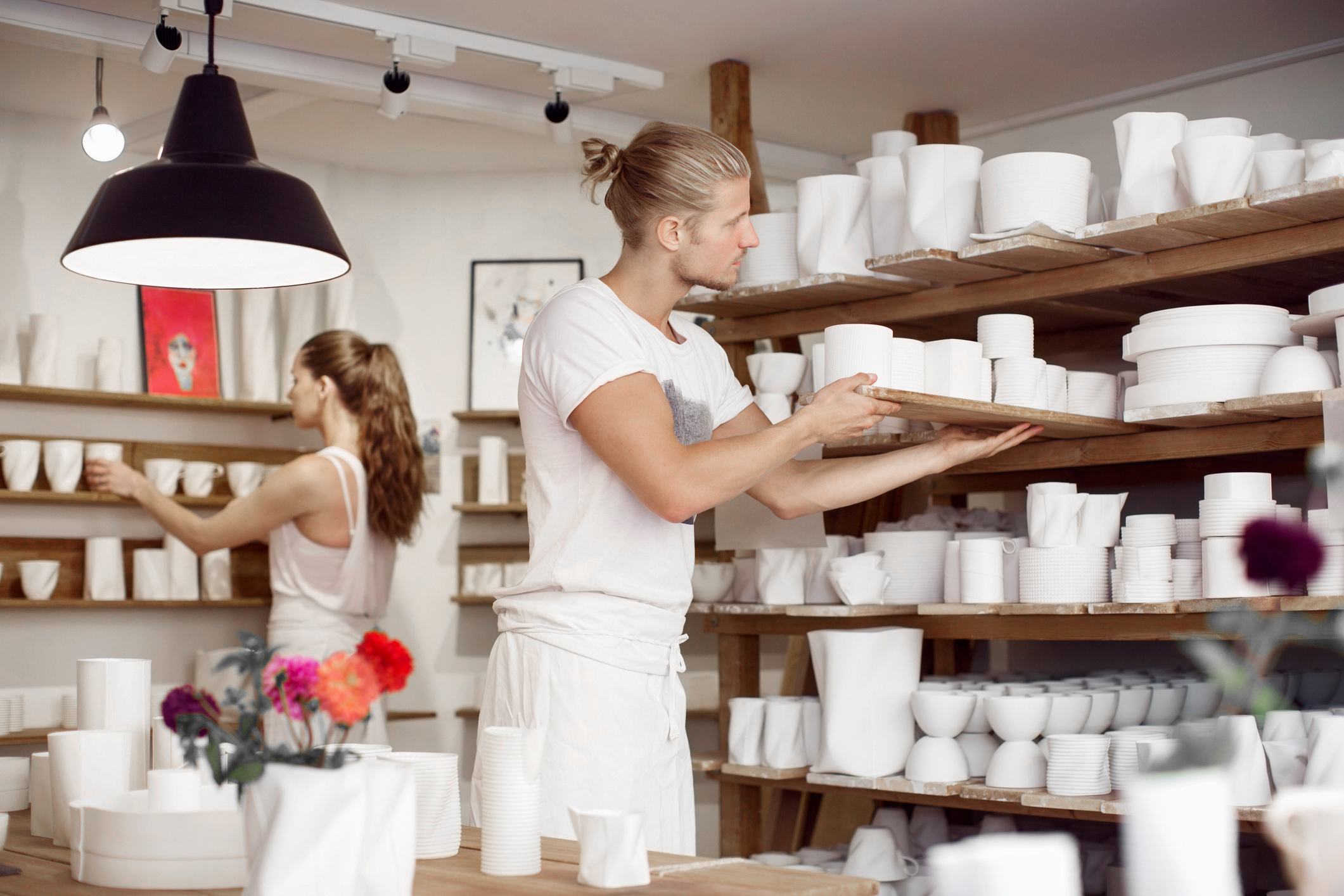 Allianz - Firmeninhaltsversicherung: Unternehmer in Porzelangeschäft gemeinsam Ware einräumend
