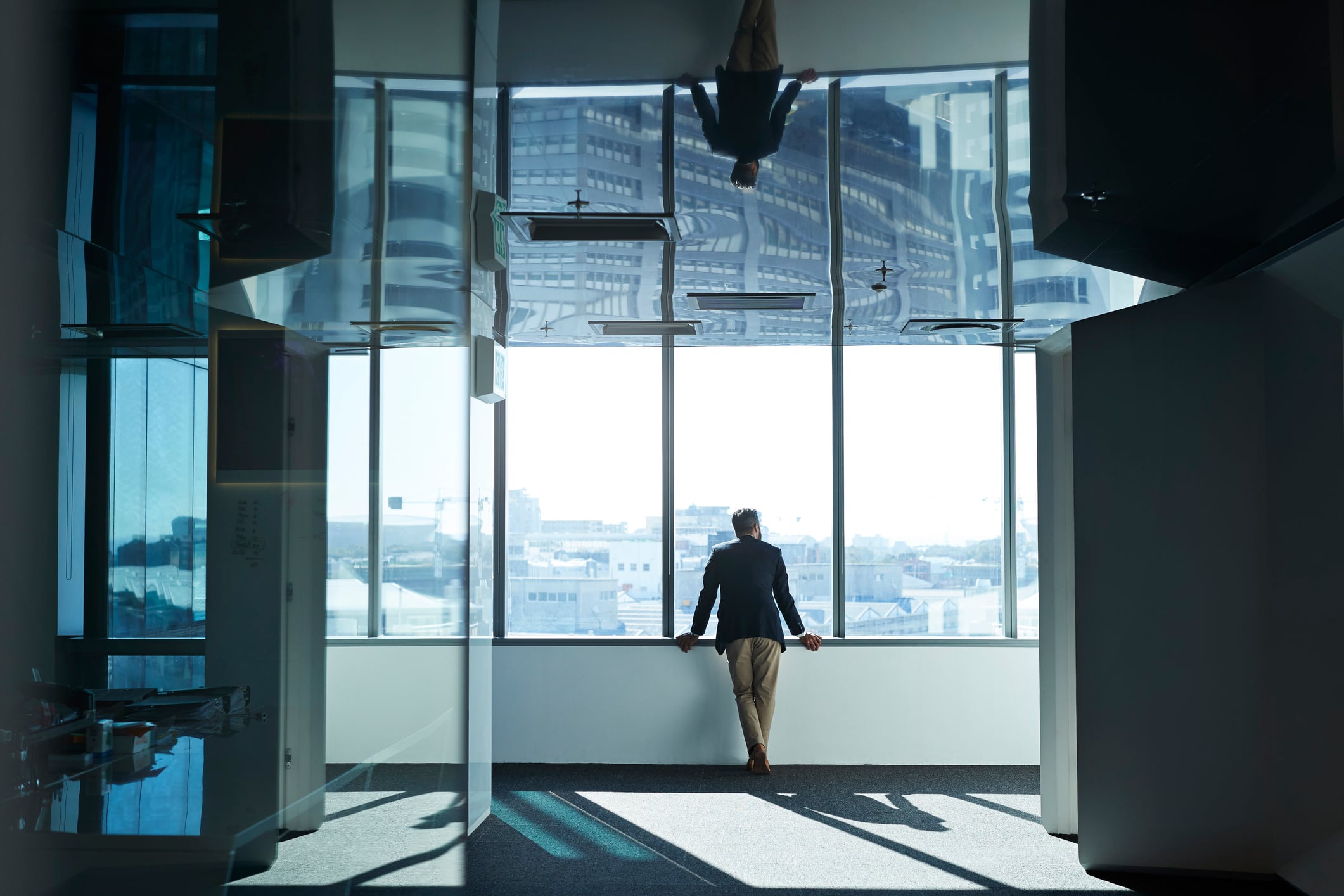 Allianz - Immobilienversicherung für Firmen: Business-Mann am Fenster