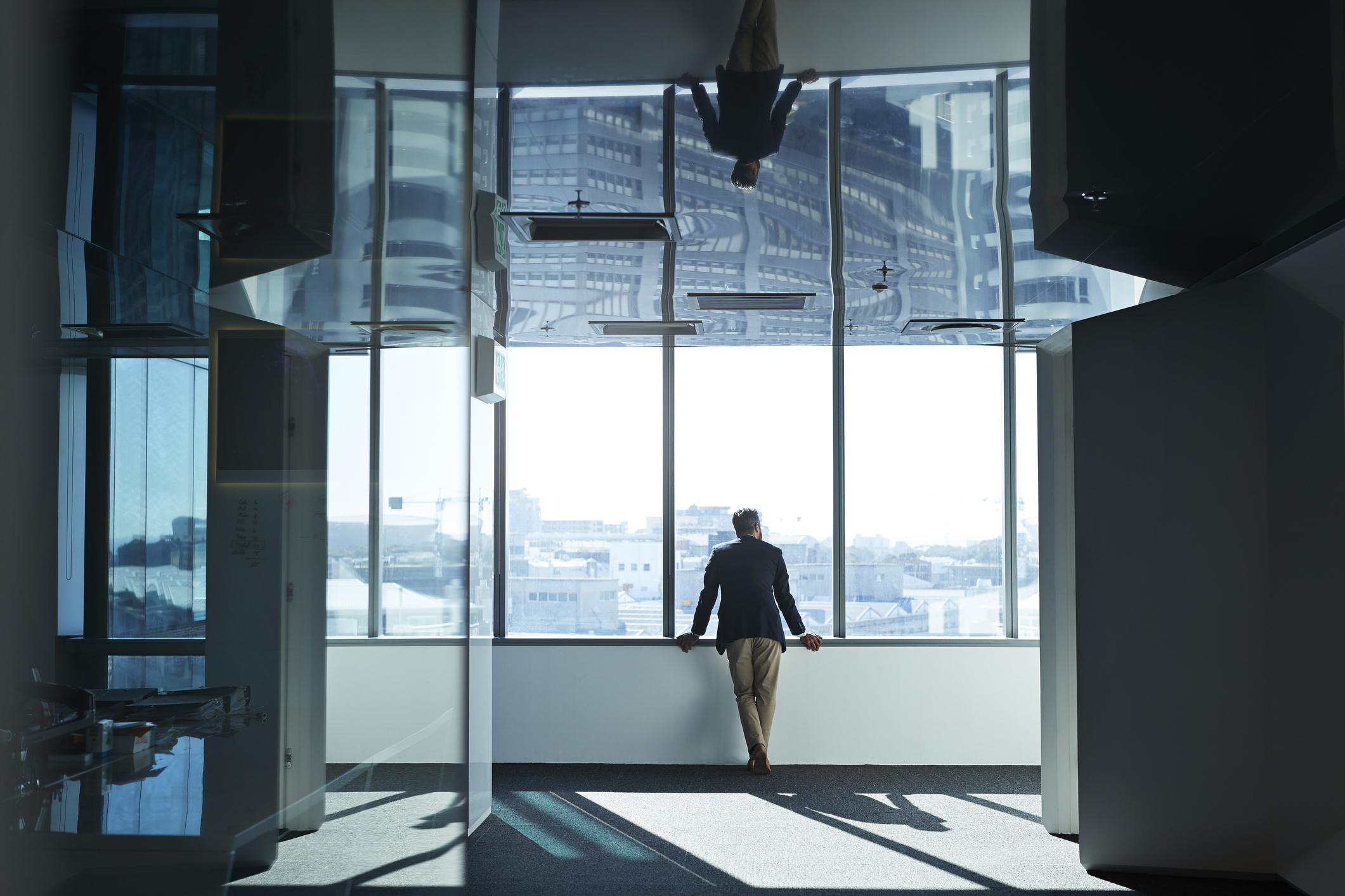 Allianz - Immobilienversicherung für Firmen: Business-Mann am Fenster
