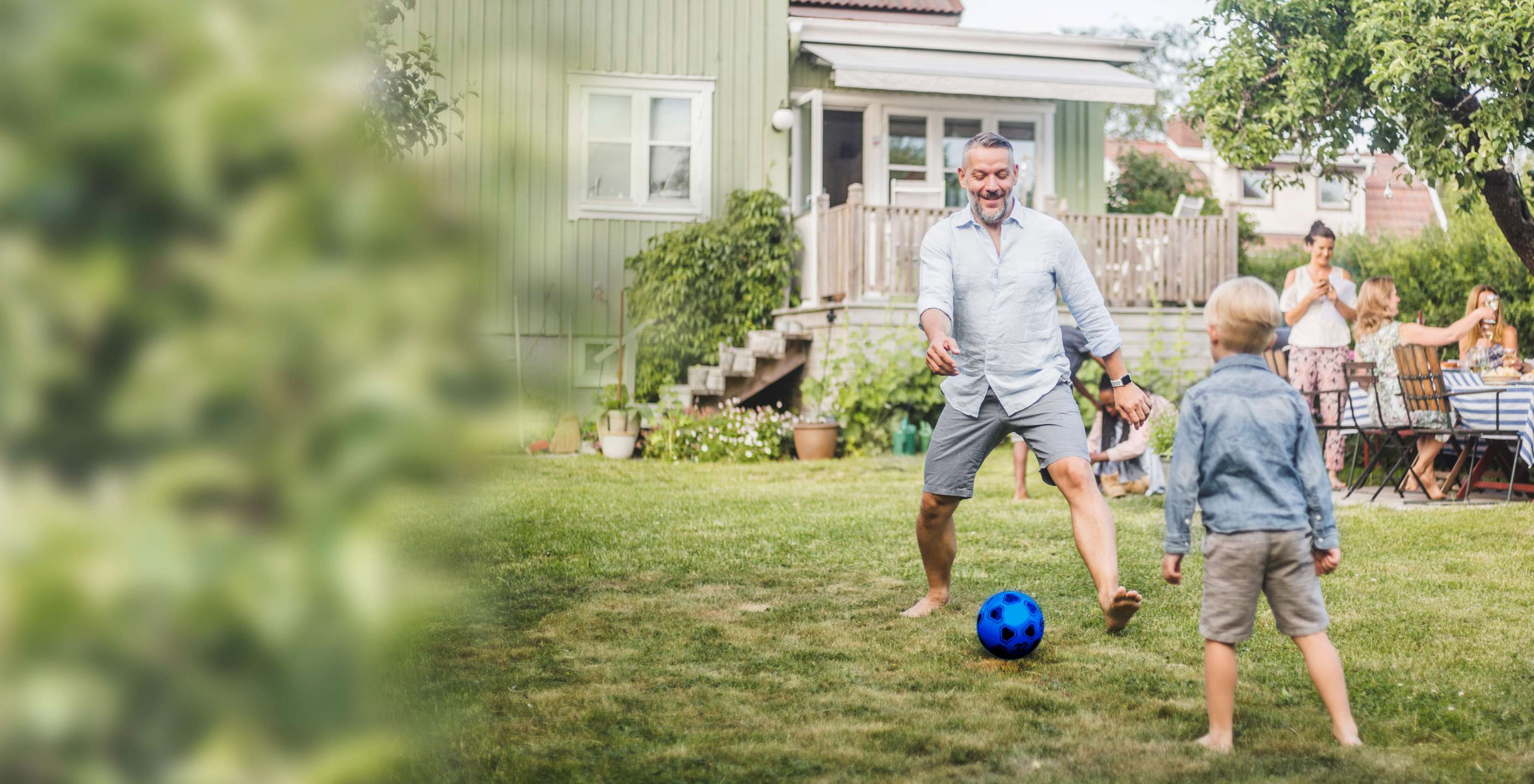 Kapitalunfallschutz: Ein Vaer spielt mit seinem Sohn im Garten Fußball