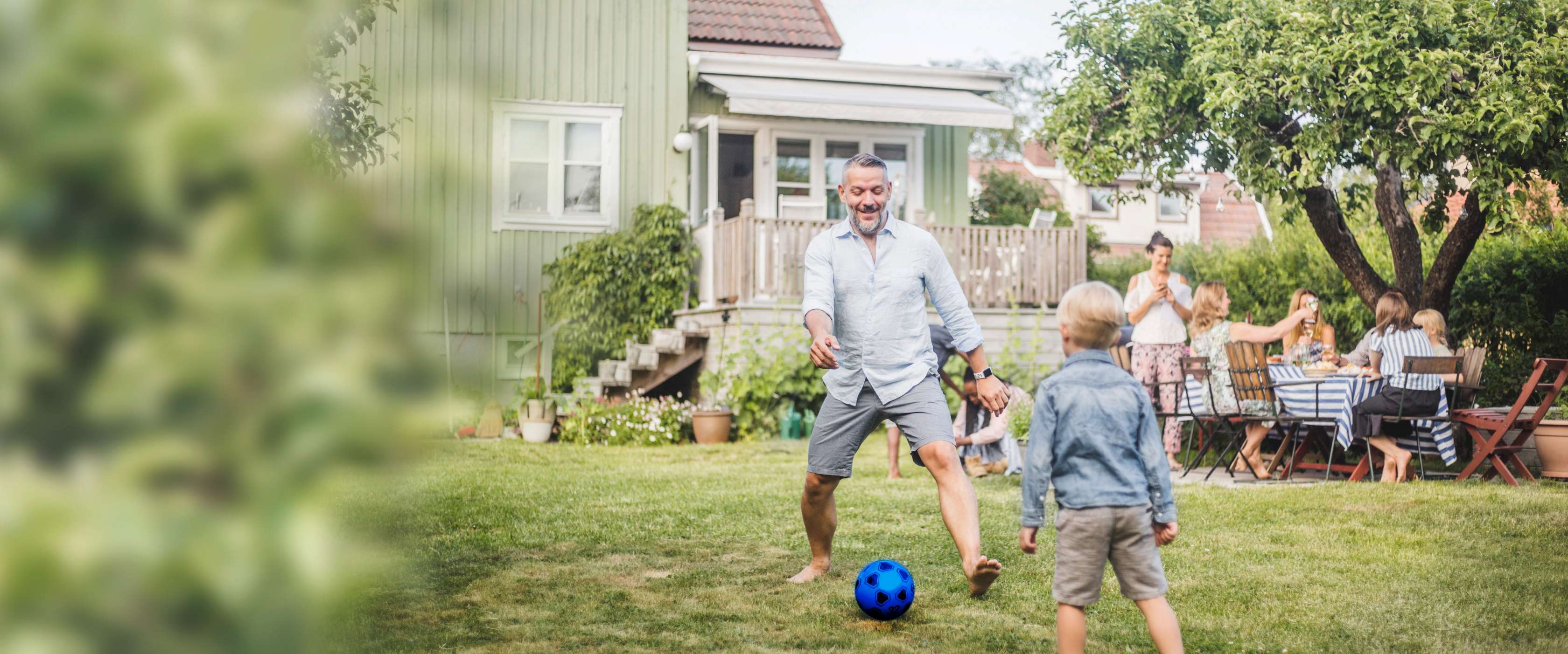 Allianz Kapitalunfallschutz: Ein Vater spielt mit seinem Sohn im Garten Fußball