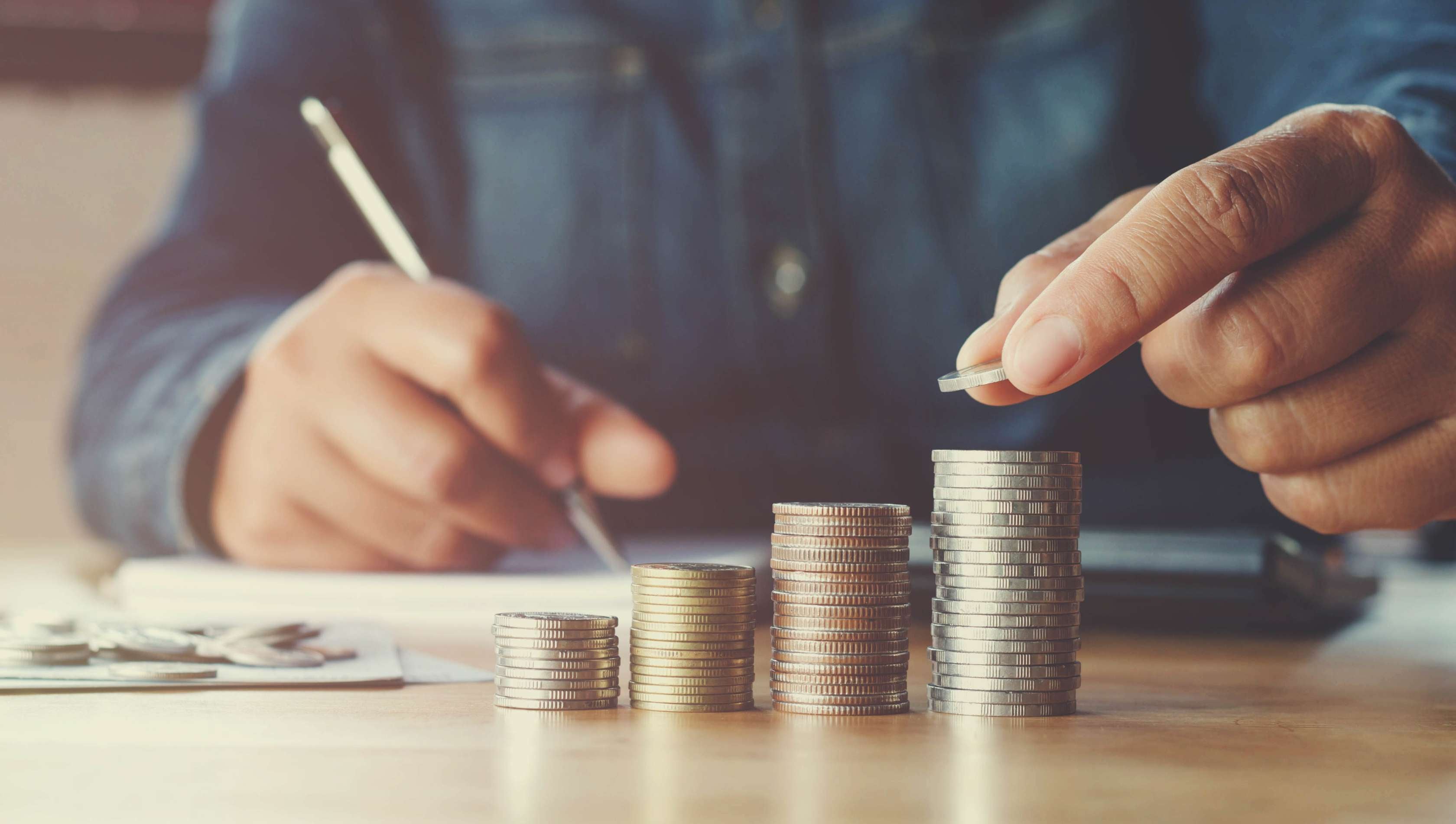 Allianz VermögensPolice - Ein Mann zählt sein Geld und baut einen Münzstapel