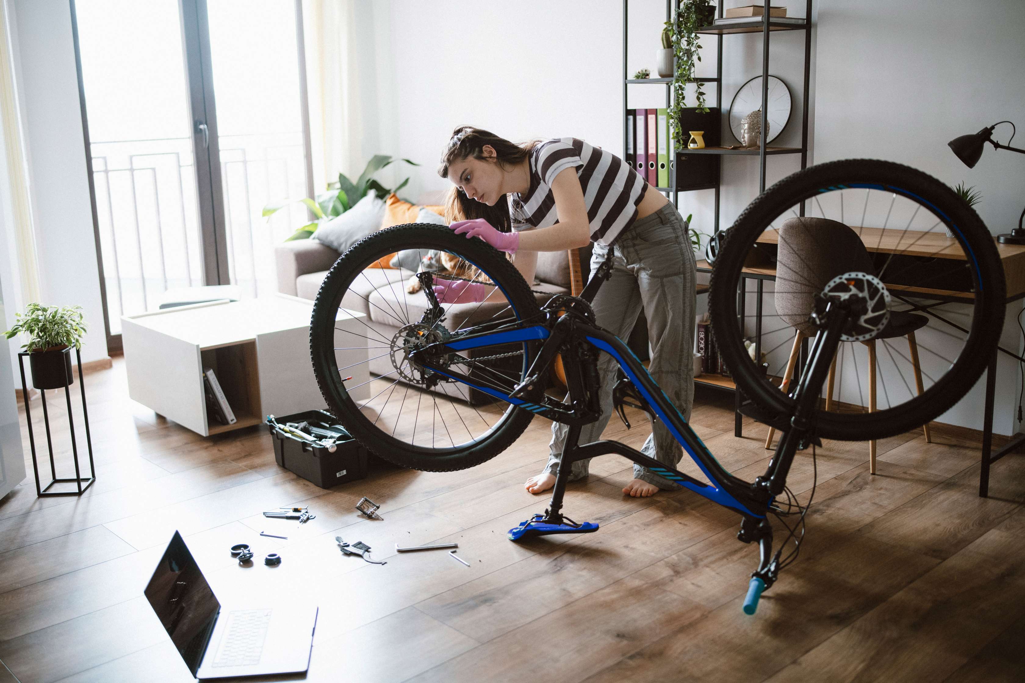 Gegenstandsschutz: Eine Frau pflegt ihr Fahrrad in ihrer Wohnung
