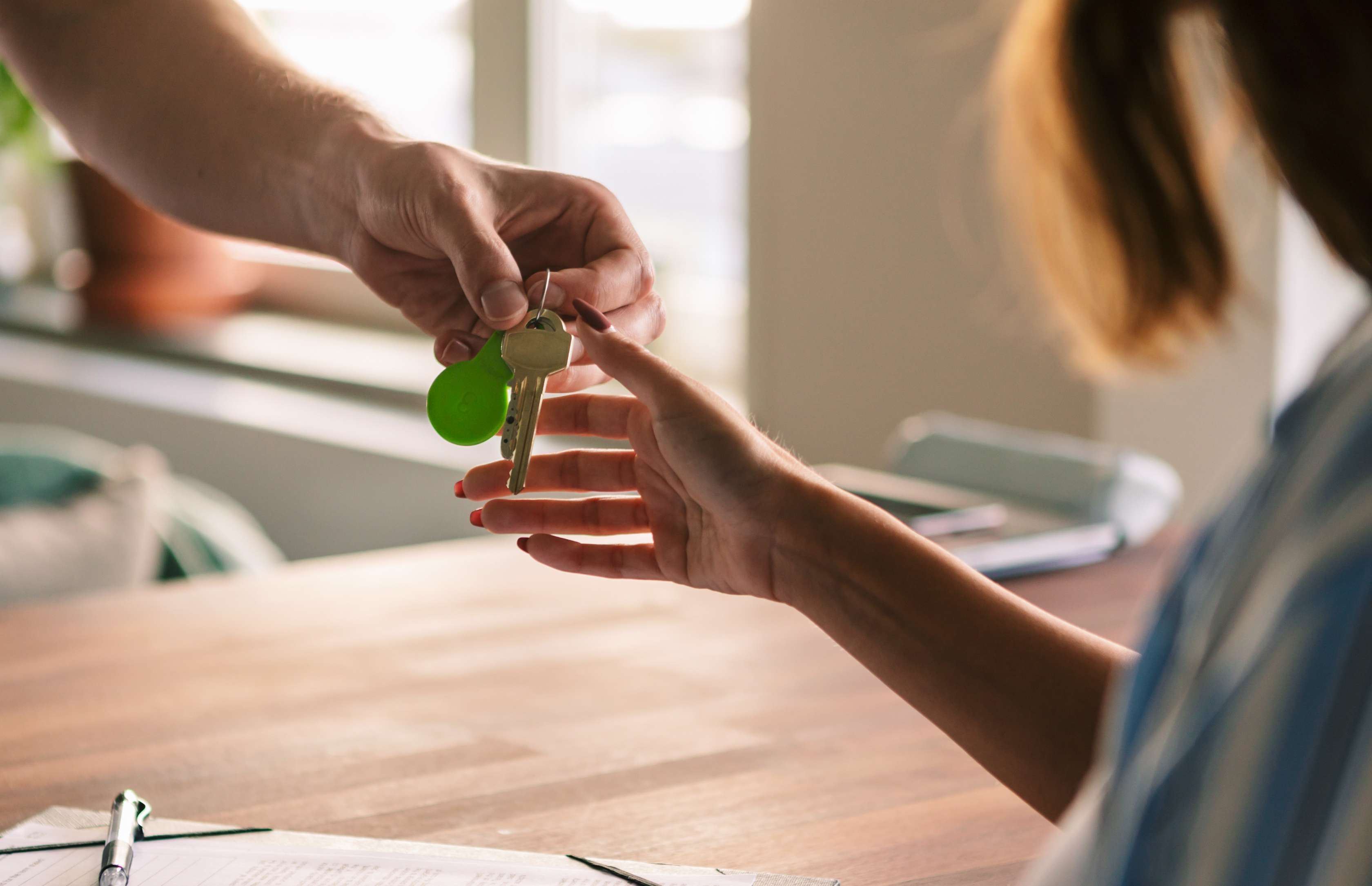 Allianz Mietrecht: Frau bekommt einen Schlüssel überreicht