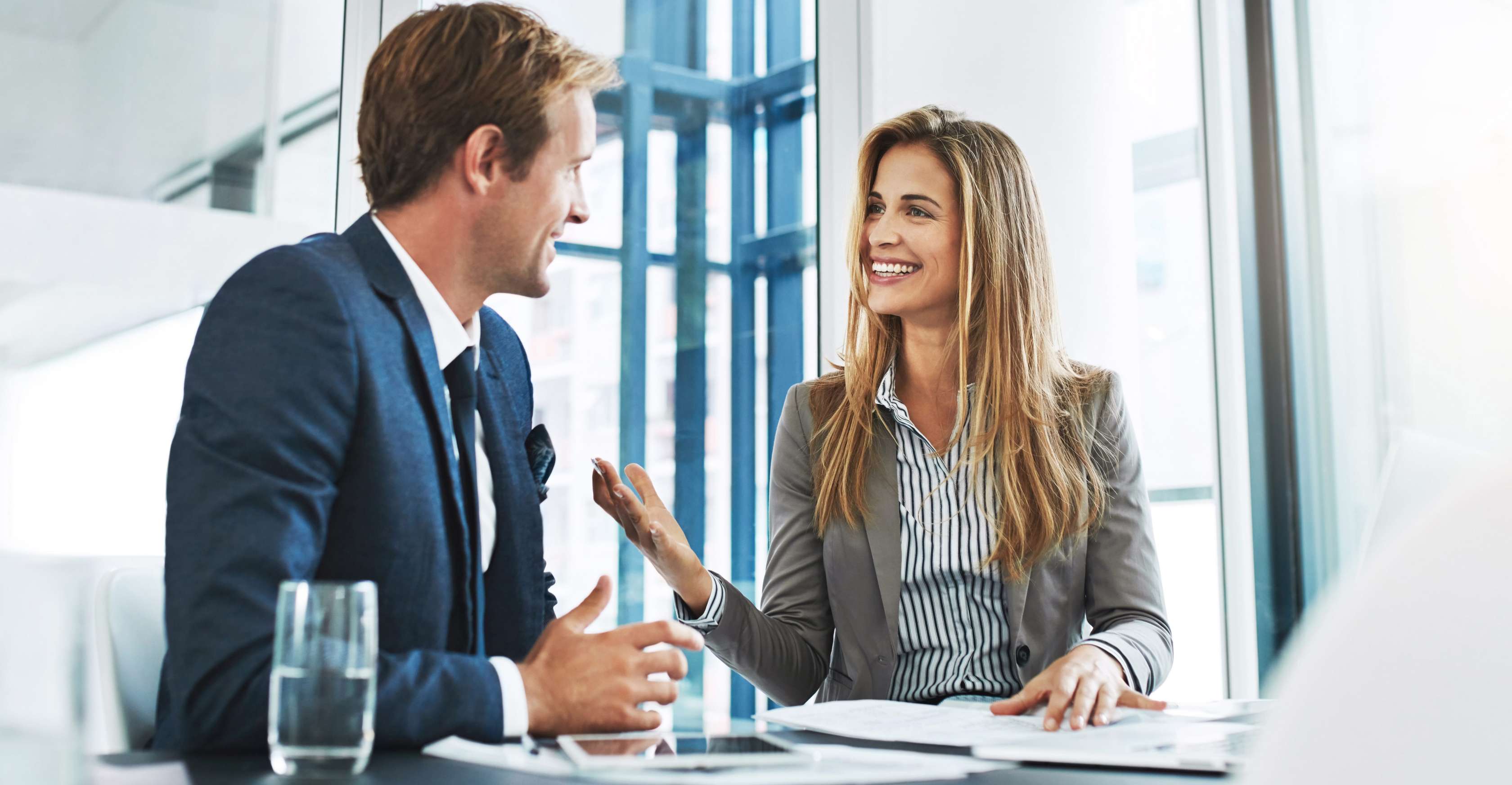 Eine Frau und ein Mann schauen sich Unterlagen an und reden.