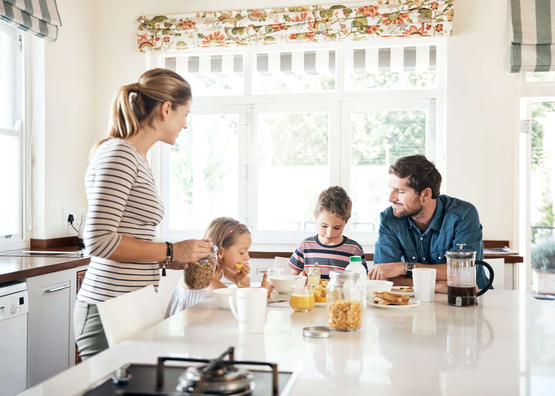 Ein junges Paar frühstückt mit seinen zwei Kindern