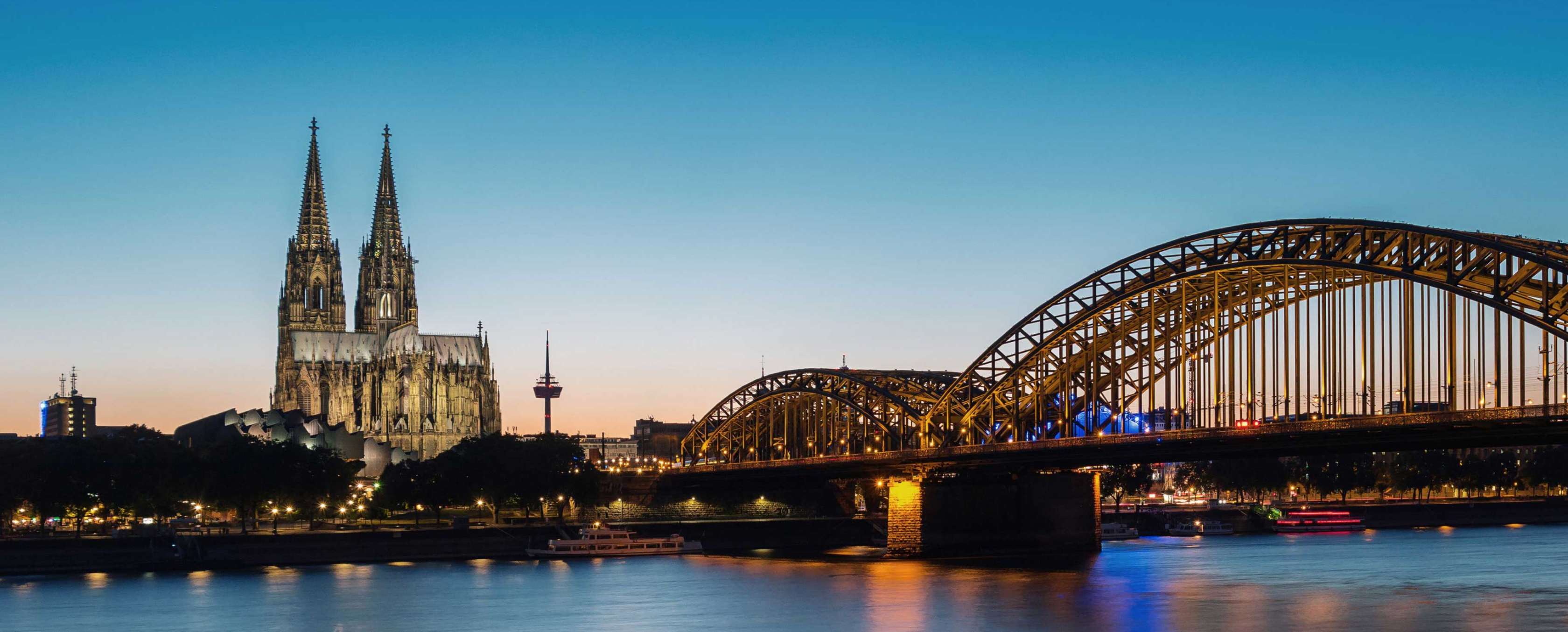 Allianz Altersvorsorge Köln: Kölner Dom und Hohenzollernbrücke am Abend