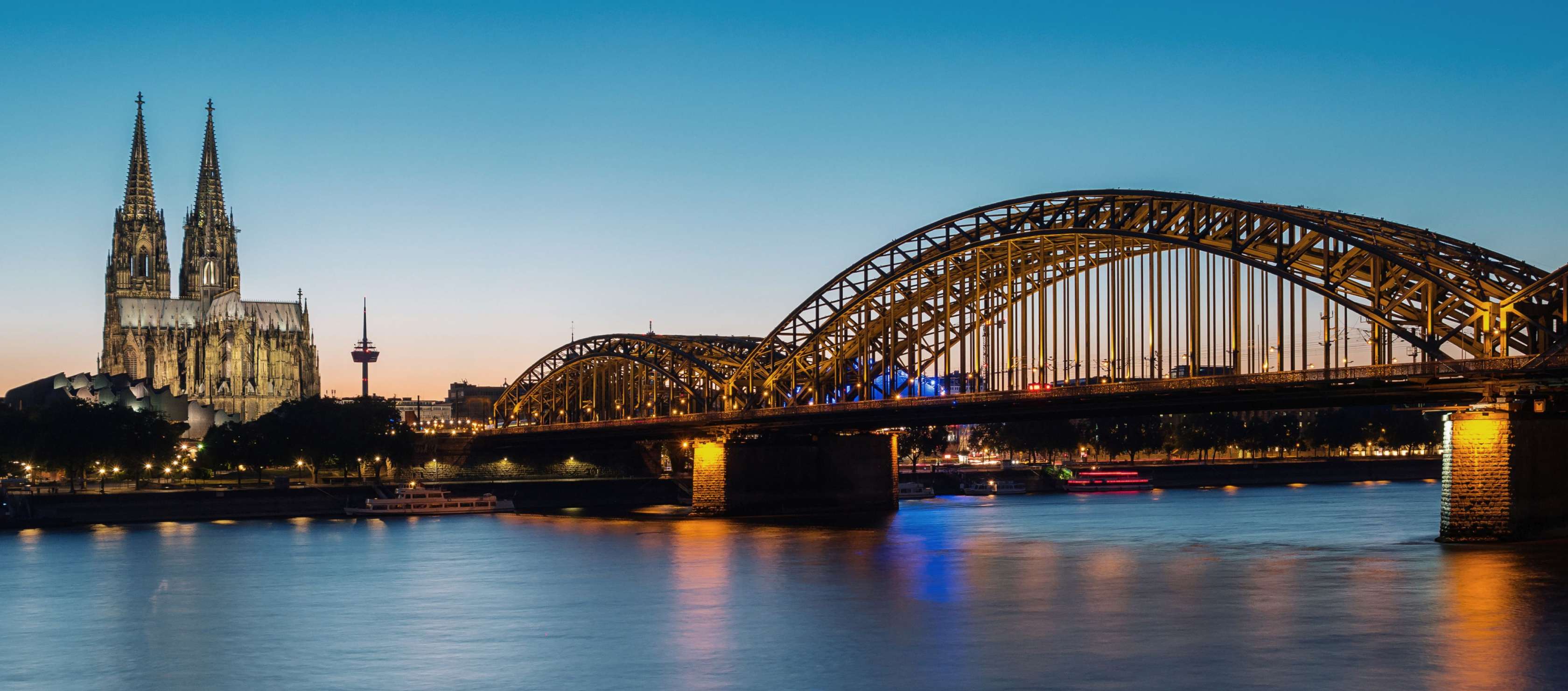 Allianz - Agentursuche Köln: Blick auf die Hohenzollnerbrücke und den Kölner Dom bei Nacht