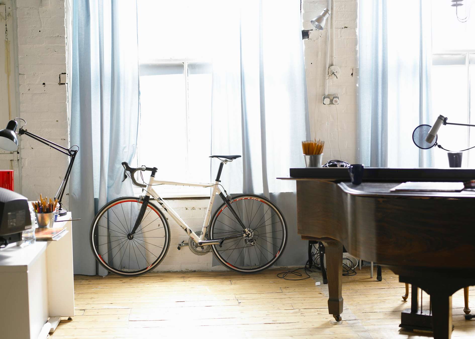 Innenraum einer Wohnung mit Fahrrad, Klavier und Schreibtisch