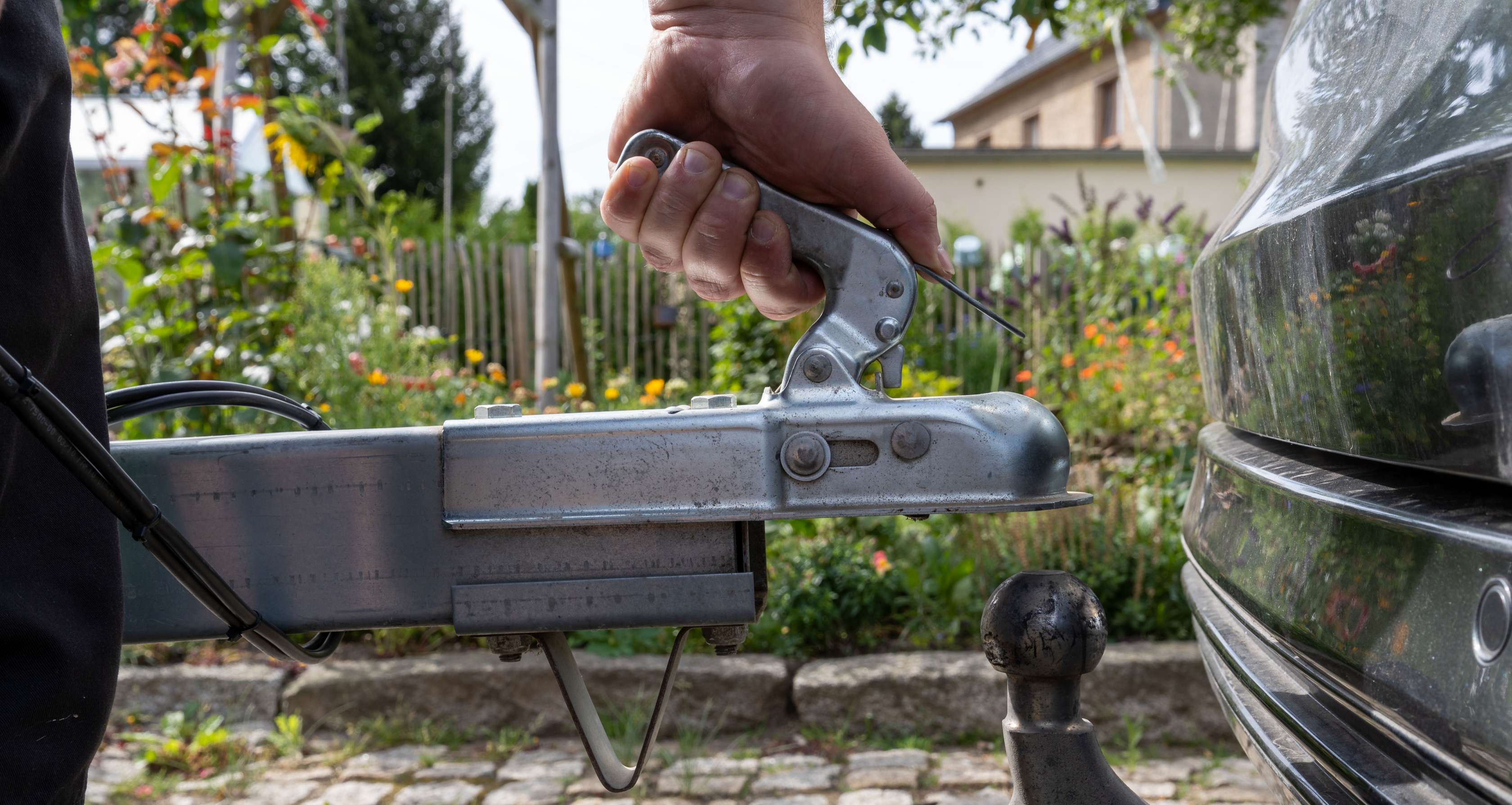 Transportanhänger: Mann hängt Anhänger an PKW an