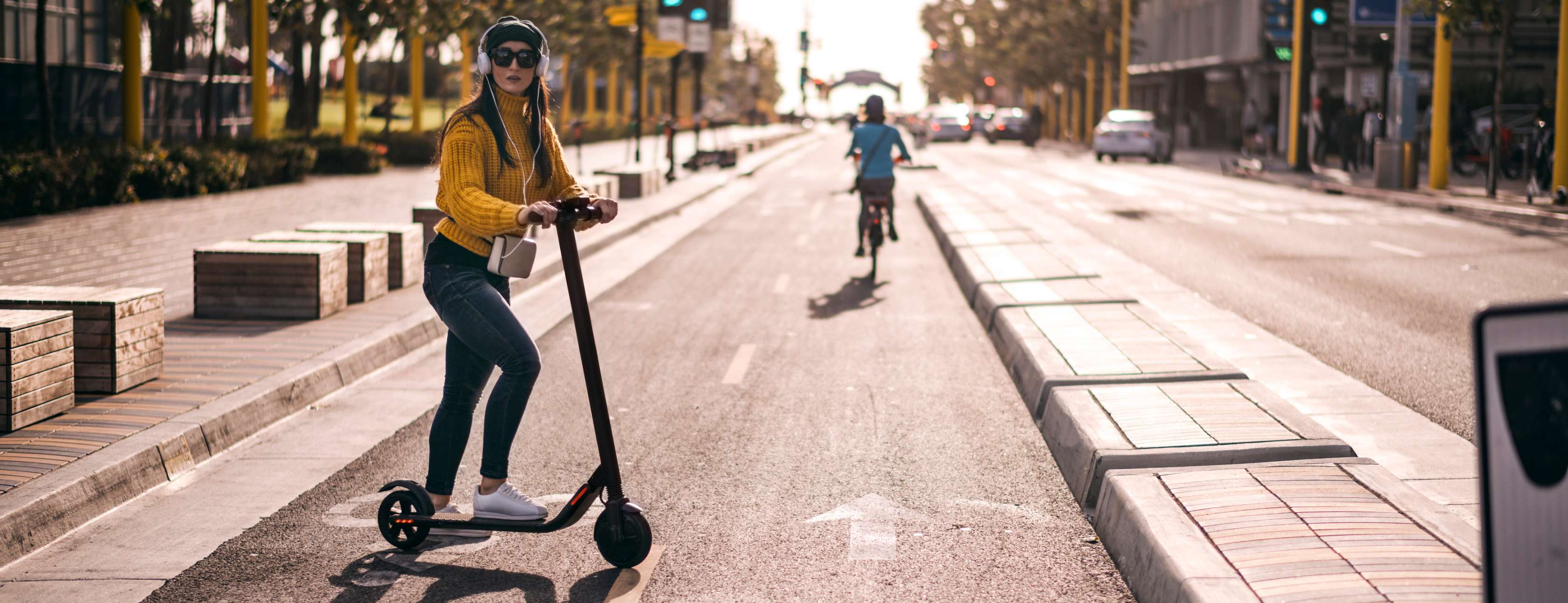 E-Scooter Versicherung: Junge Frau überquert mit Elektro-Tretroller eine Straße