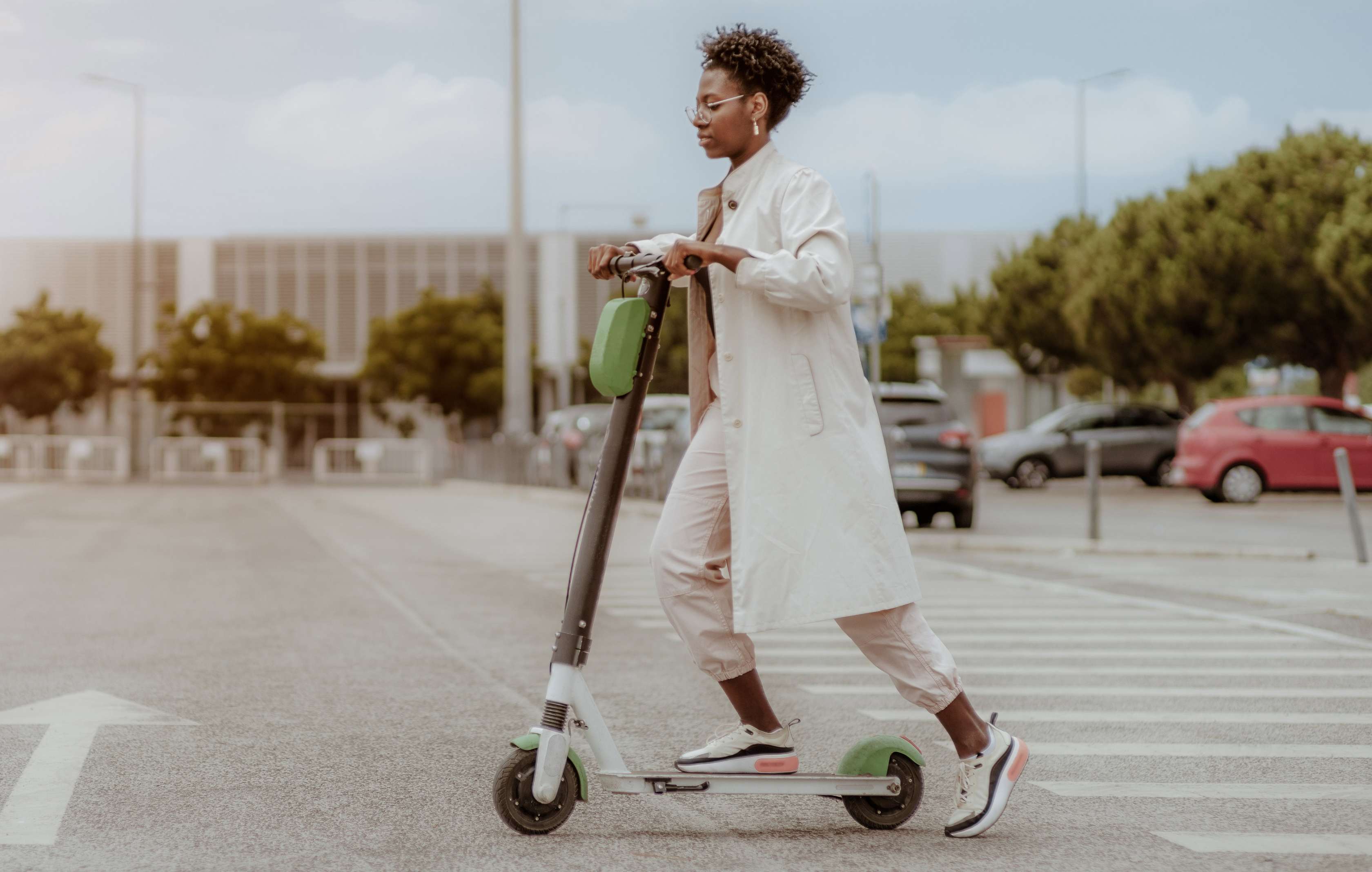 E-Scooter Diebstahlschutz: Eine Frau fährt mit einem E-Scooter durch die Straßen