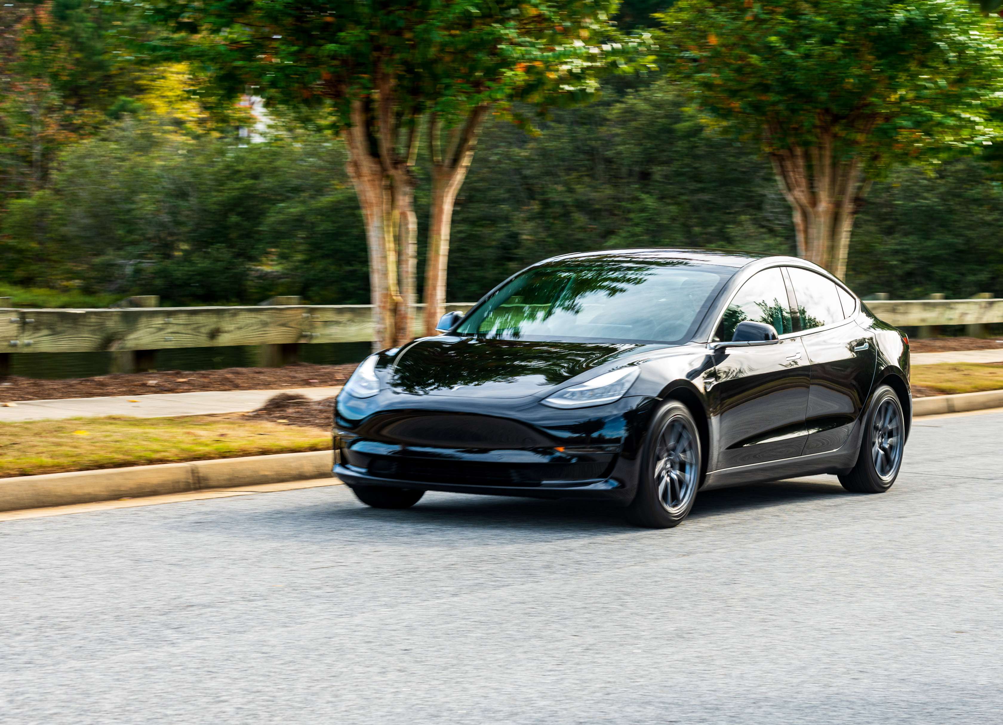 Reichweite Elektroauto: Schwarzer Tesla fährt auf einer Straße