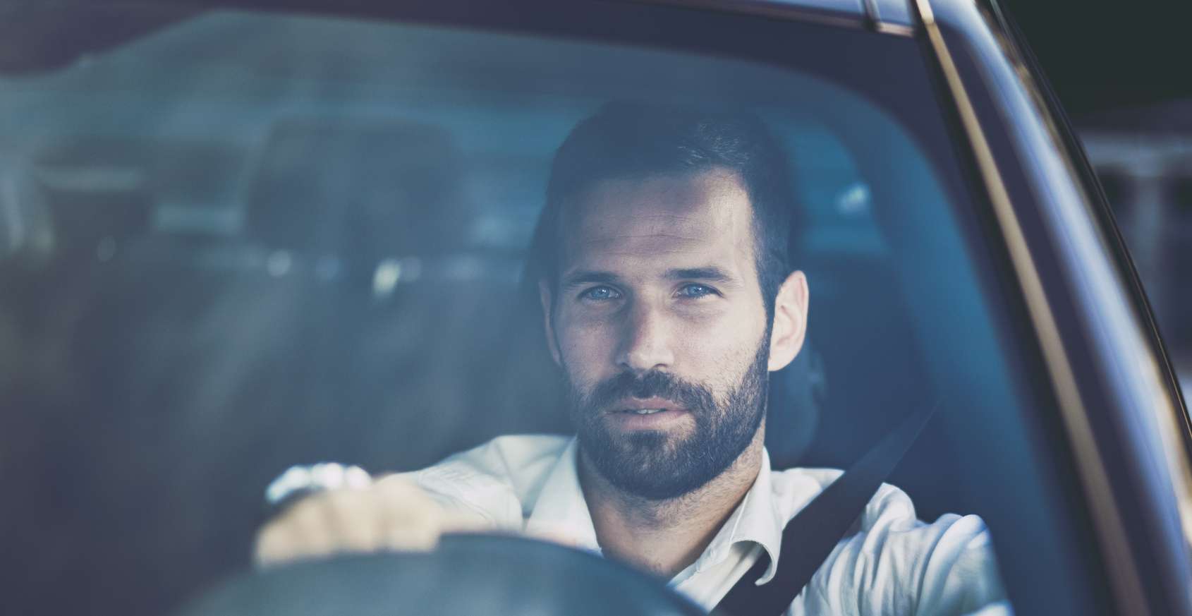 Fahren ohne Versicherungsschutz: Mann sitzt am Steuer eines schwarzen Autos