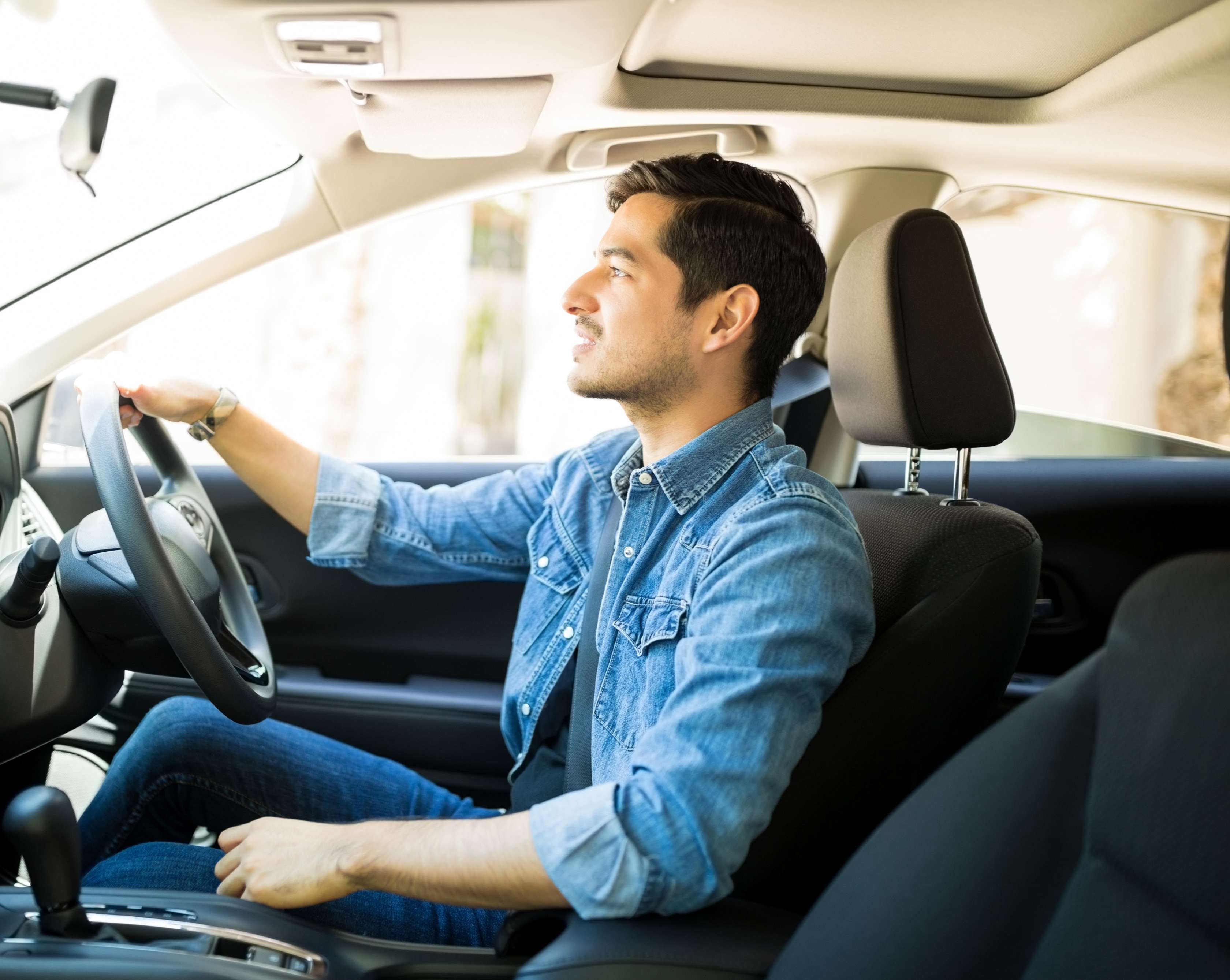 Vollkasko: Mann sitzt am Steuer eines Autos und konzentriert sich auf die Straße