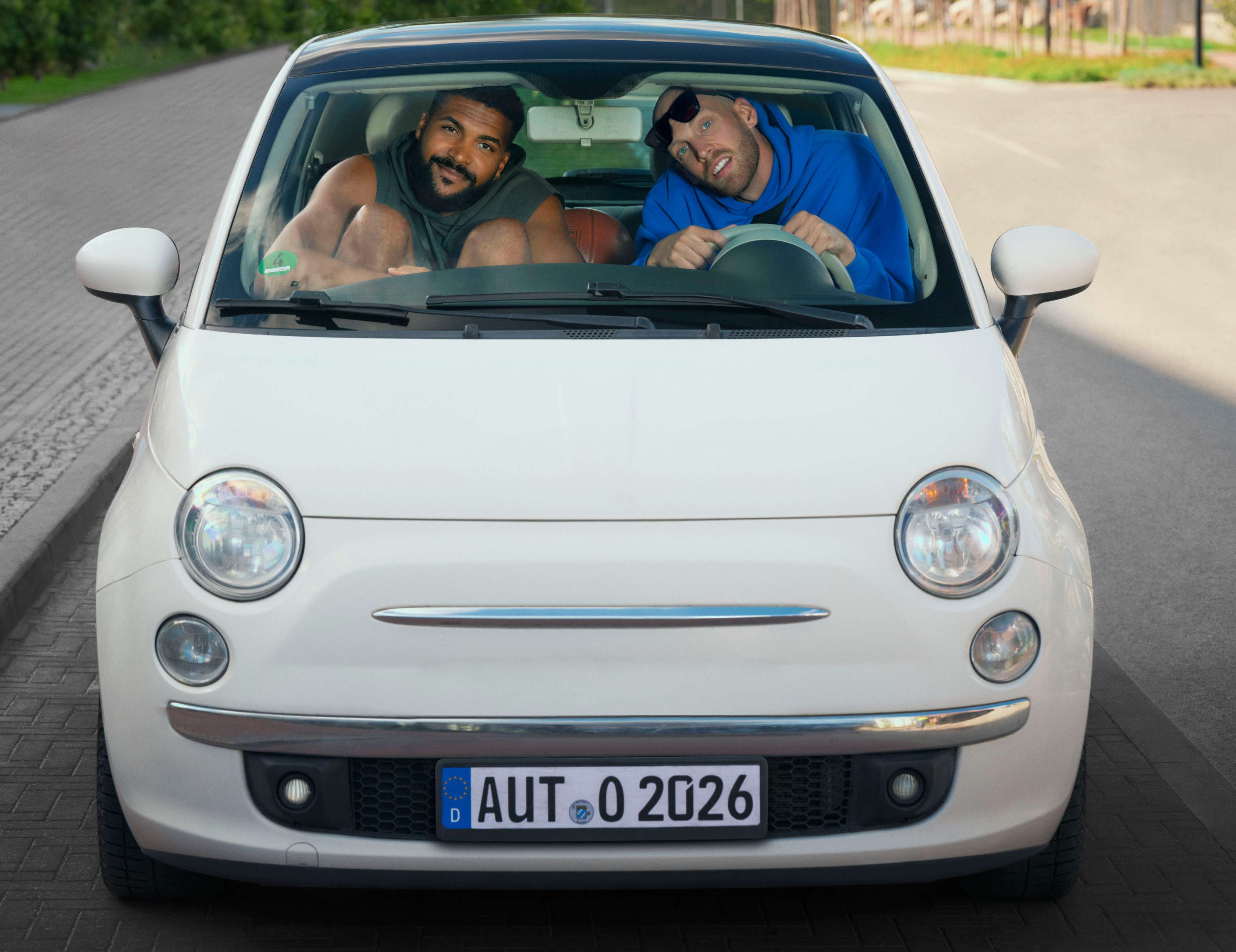 Werstattbindung: zwei sehr große Basketballprofis sitzen ein einem sehr kleinen Auto