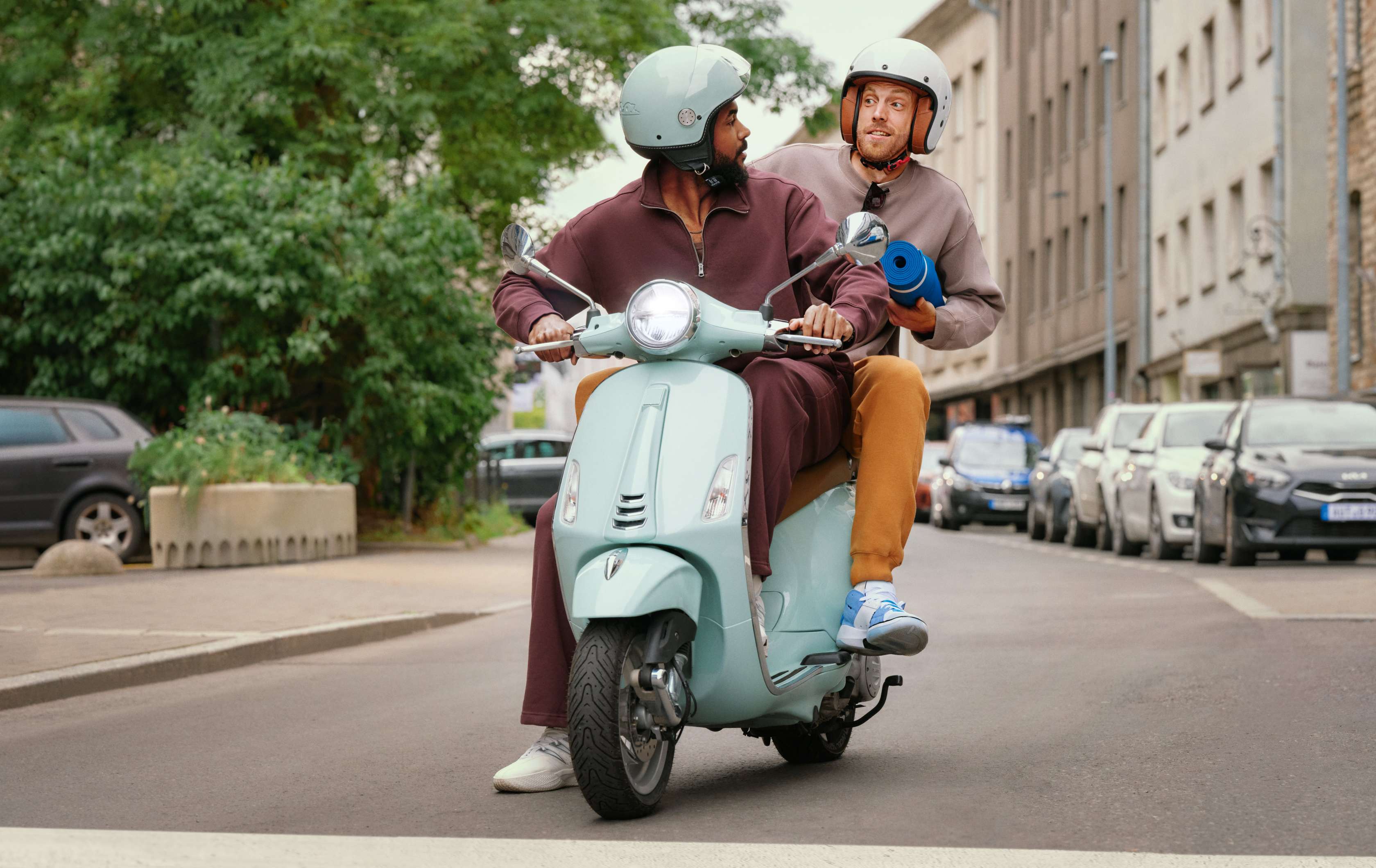 Allianz Mopedversicherung: Eine junge Frau fährt mit einem Moped durch die Stadt