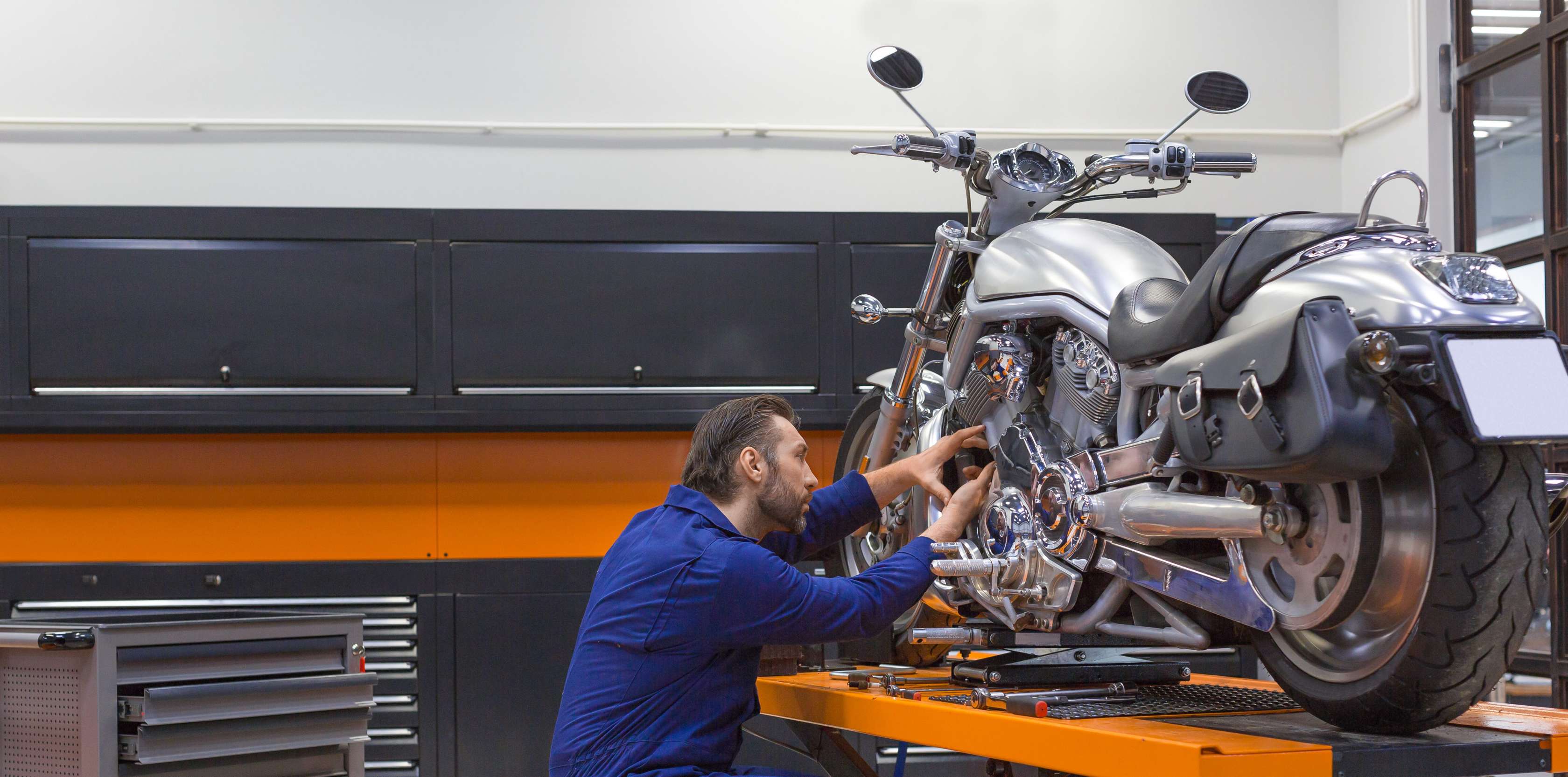 Motorschaden bei Vollkasko: Motorrad steht in Werkstatt und wird von Mechaniker bearbeitet