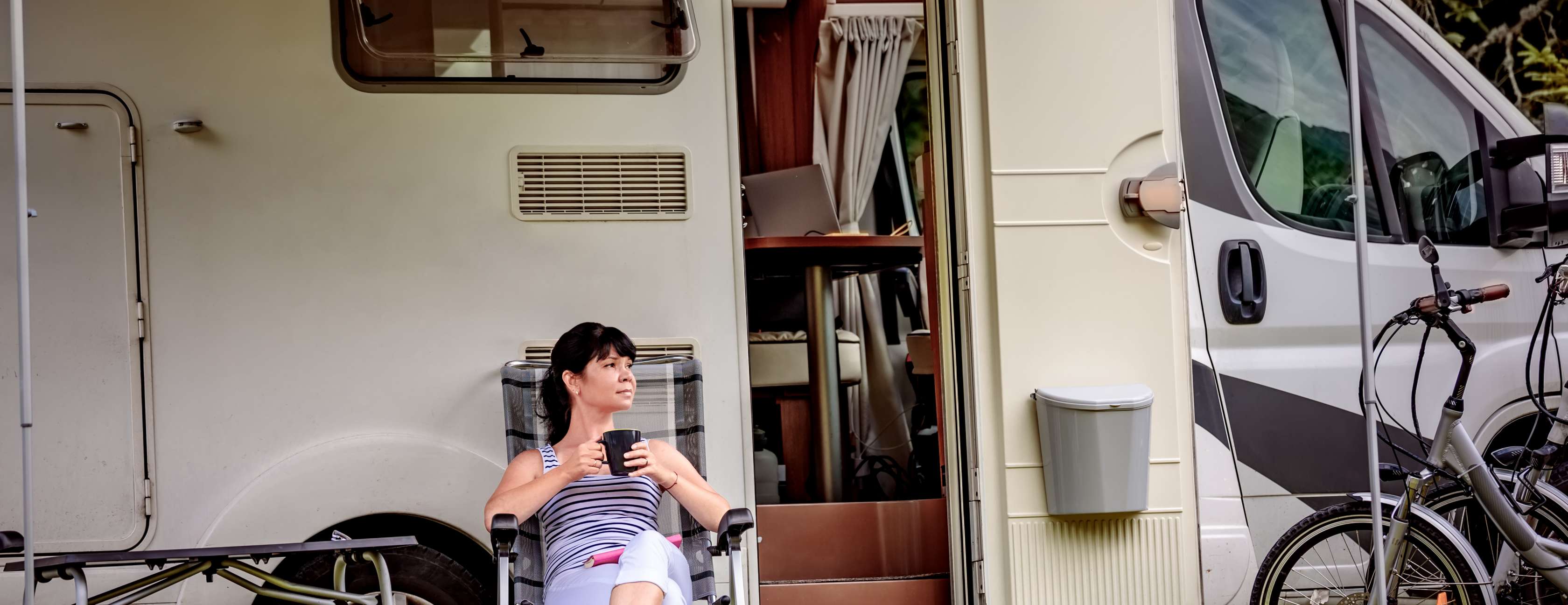 Frau sitzt vor einem Wohnmobil