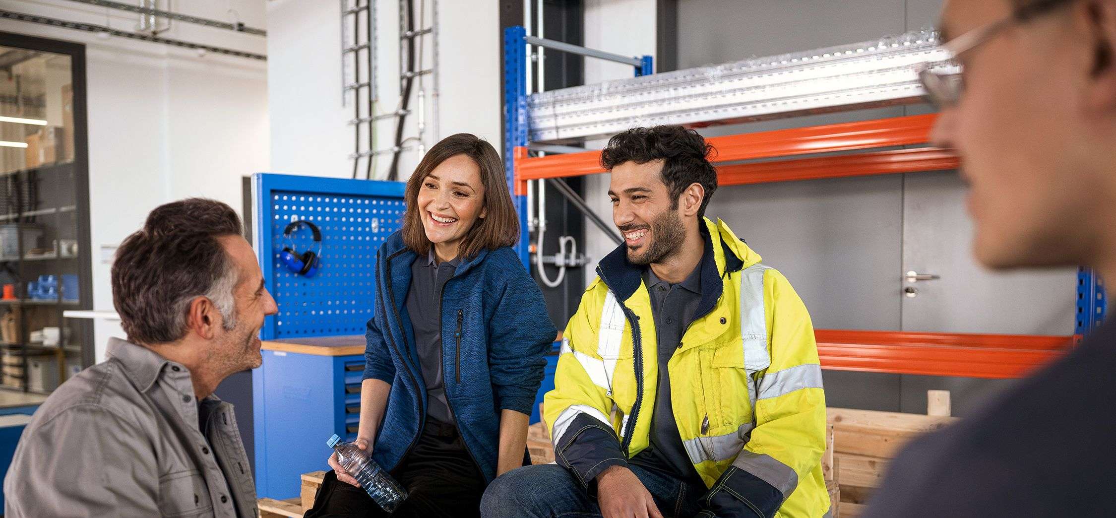 Allianz Betriebliche Krankenversicherung: Drei Personen stehen in einem Besprechungsraum und  unterhalten sich.