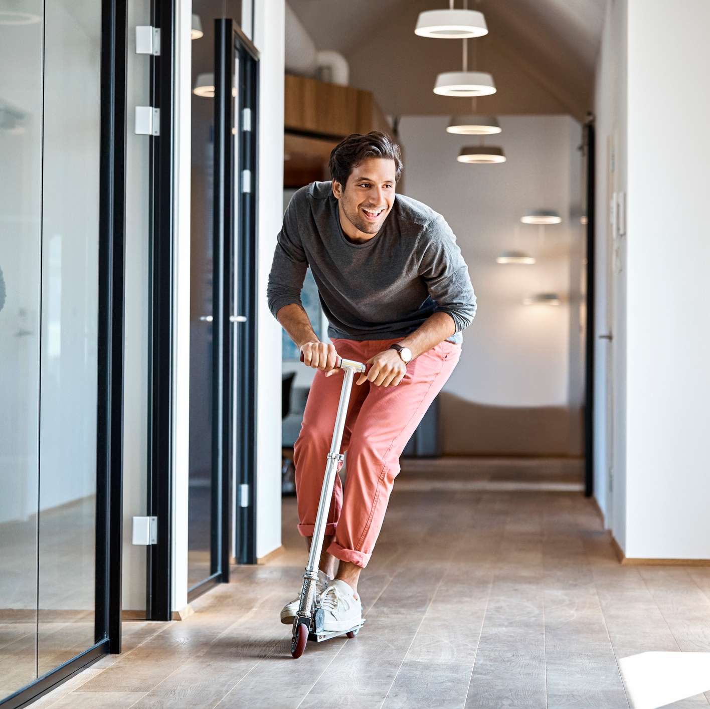 Allianz - Haus-Haftpflichtversicherung: Mann fährt mit Roller durch das Büro