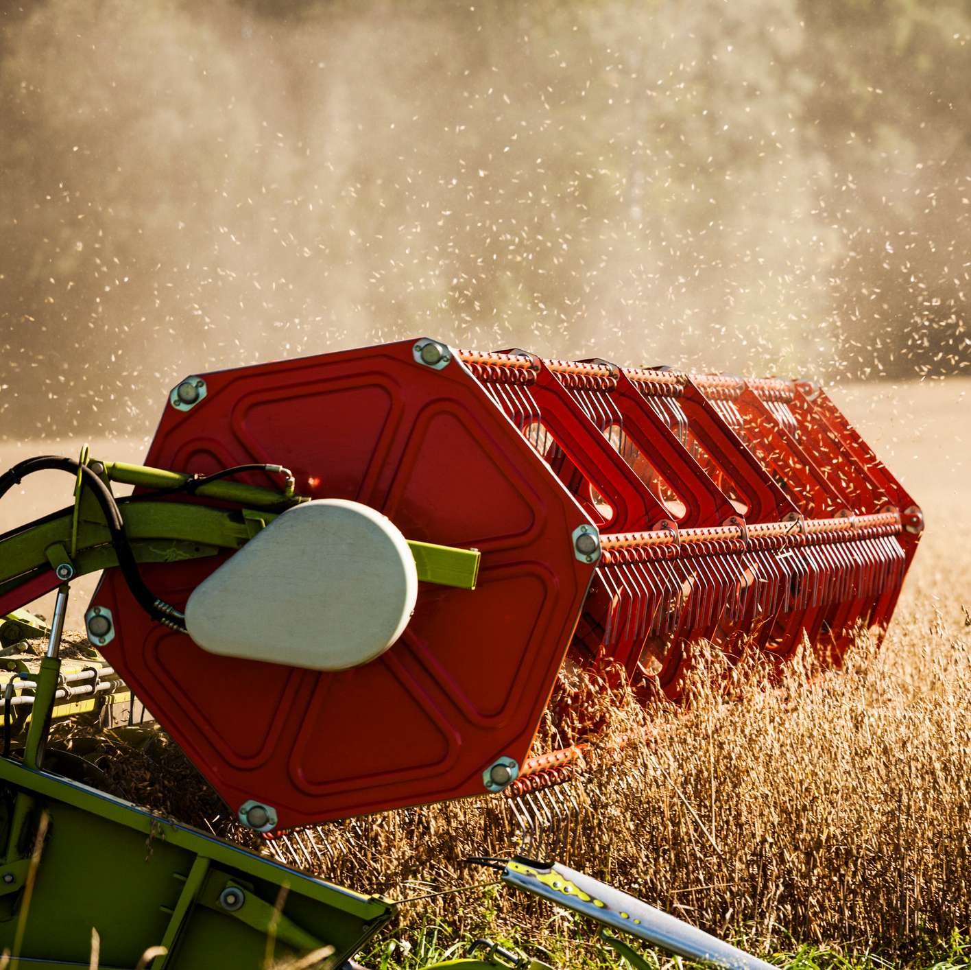 Allianz - Landwirtschaftliche Inhaltsversicherung: Ausschnitt einer landwirtschaftlichen Maschine auf einem Weizenfeld