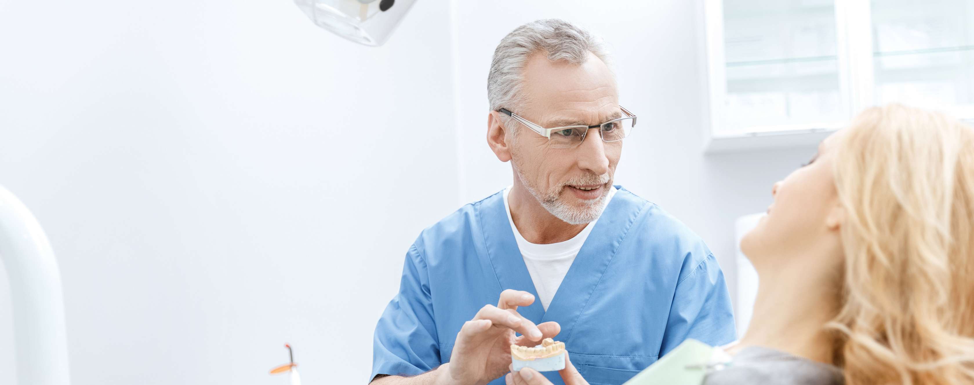 Zahnarztversicherung: Zahnarzt bespricht Behandlungsplan an einem Gebissmodell