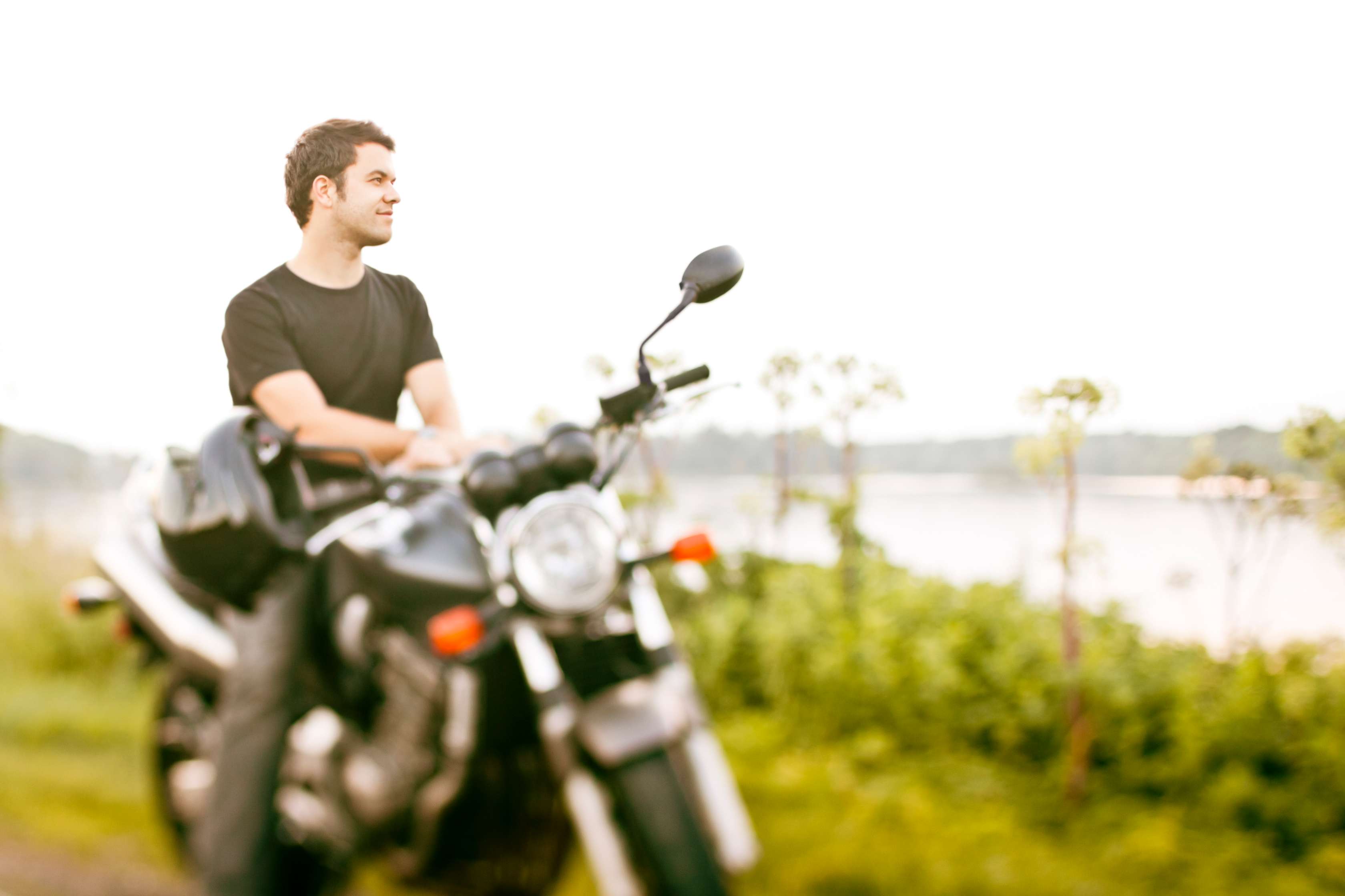 Allianz - Motorradversicherung: Mann auf Motorrad blickt in die Ferne
