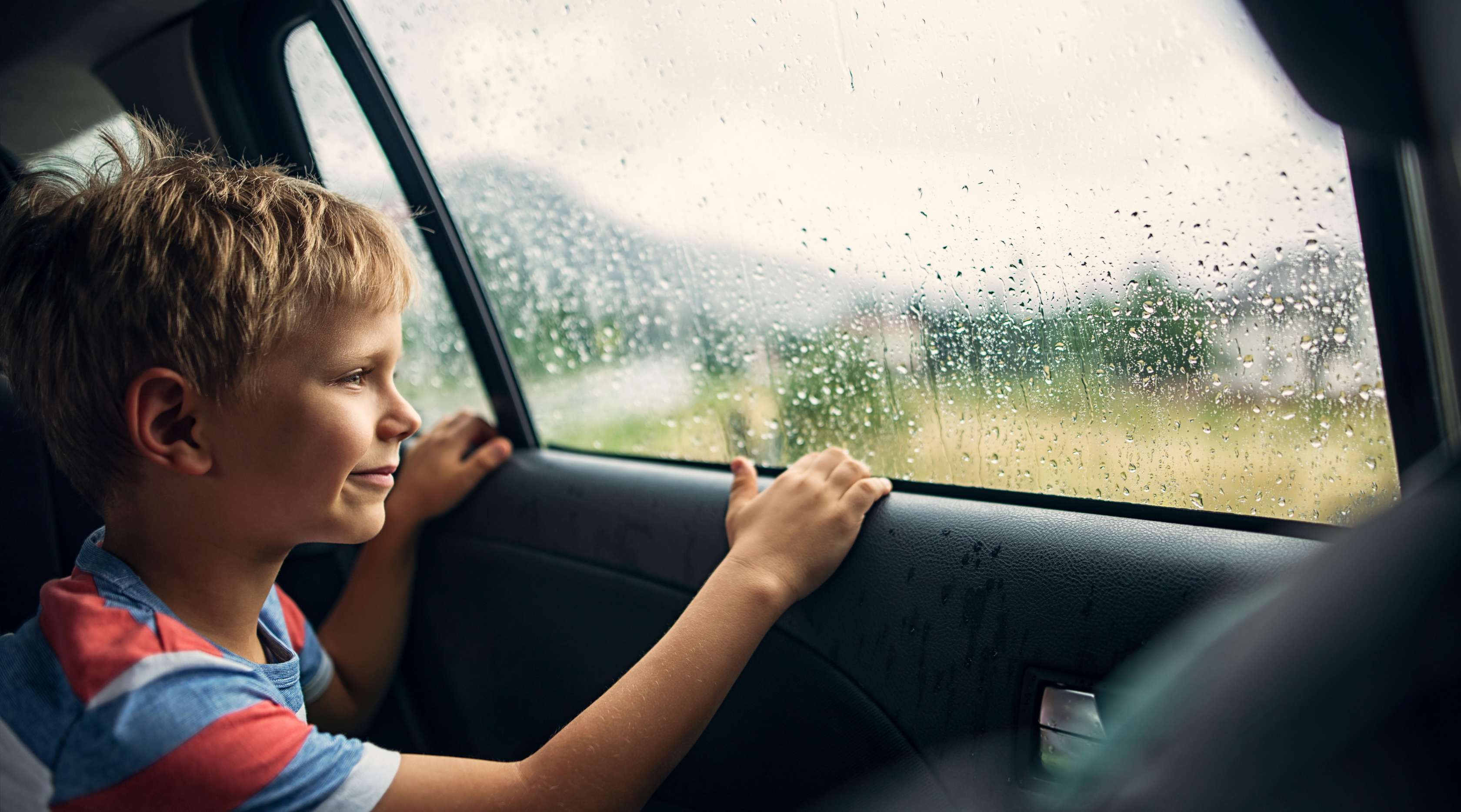 Allianz - Teilkasko: Junge im Auto bei Regen