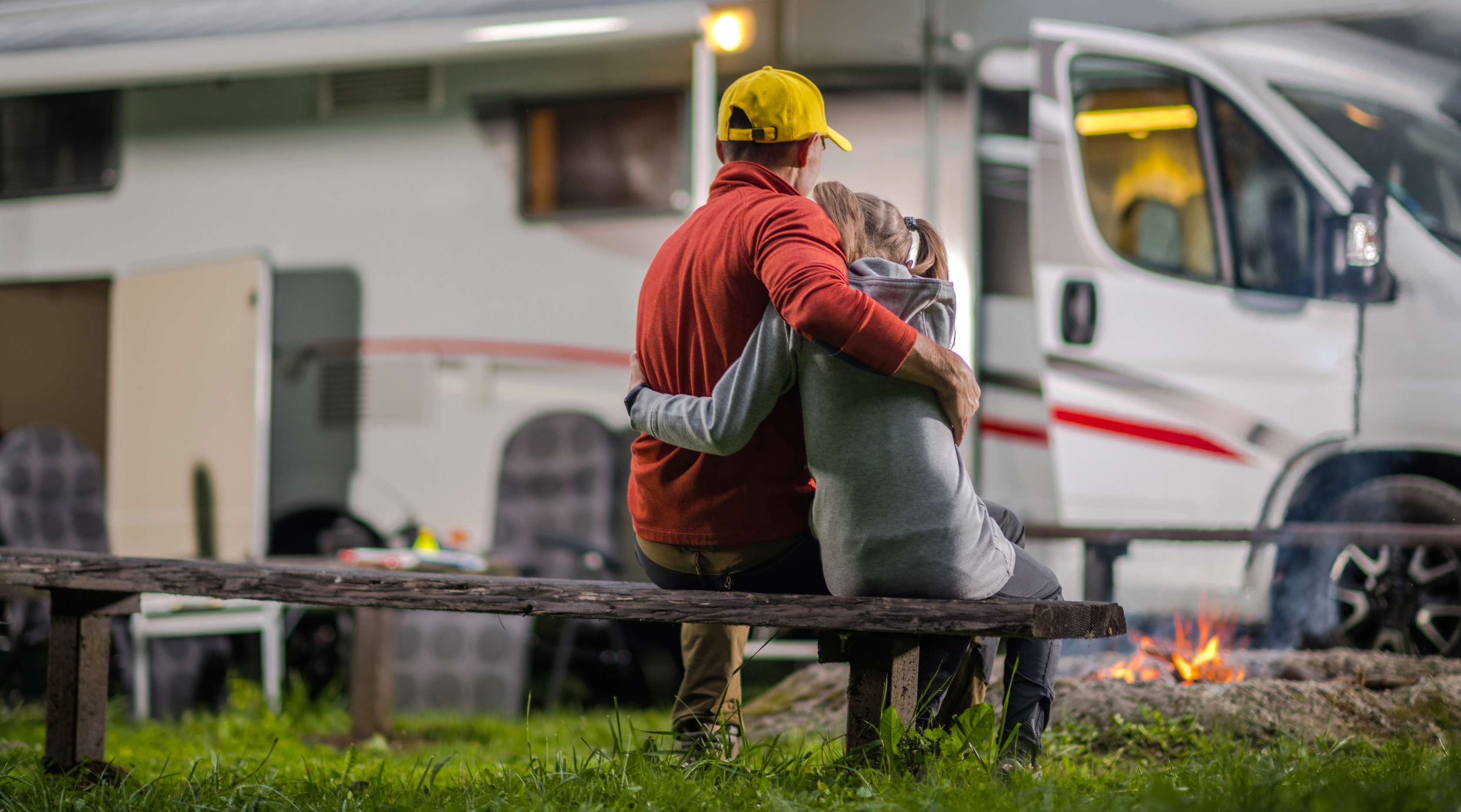 Vater sitzt mit Tochter vor Wohnmobil