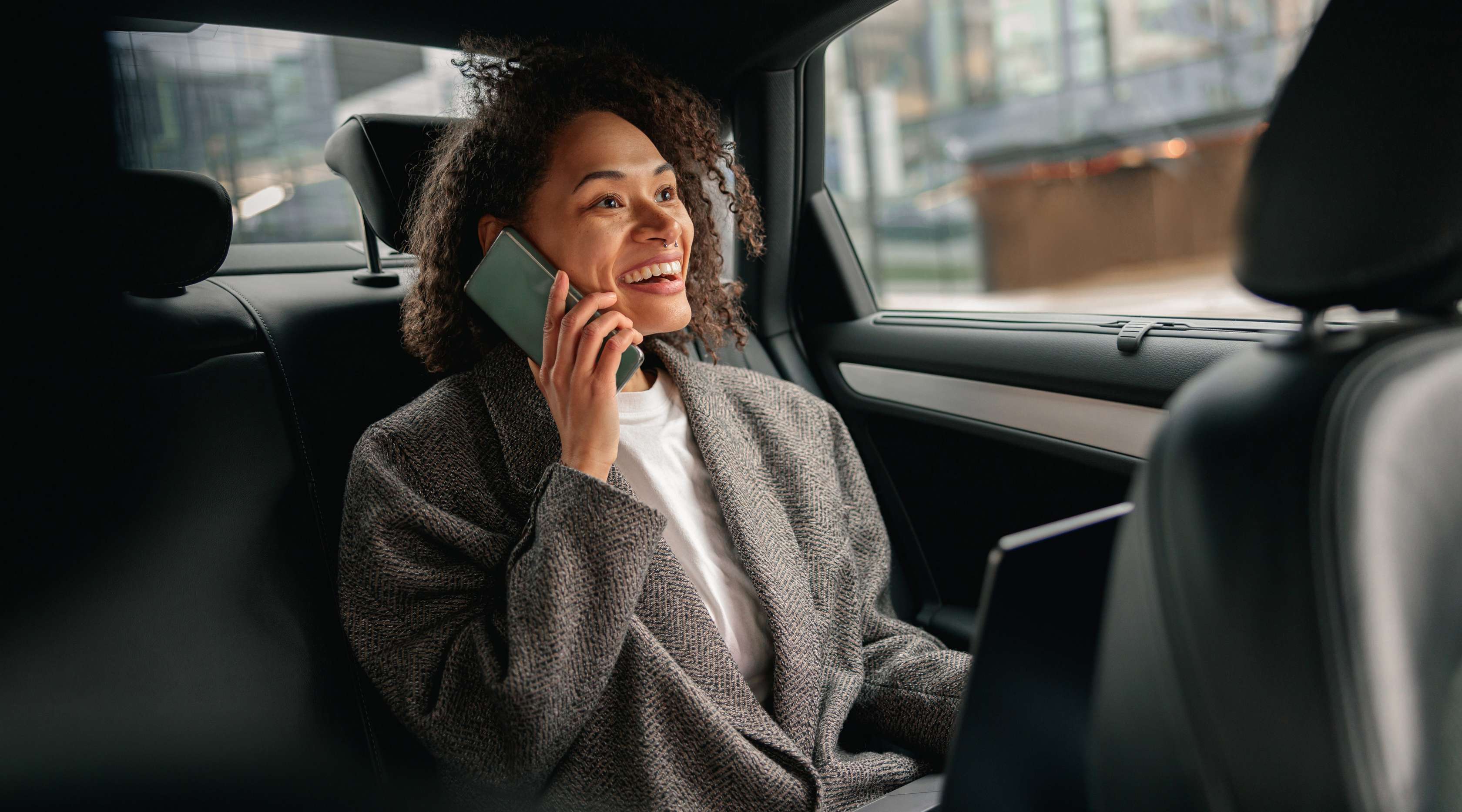 Allianz - KFZ-Vollkaskoversicherung - Businessmann sitzt hinten im Auto und telefoniert