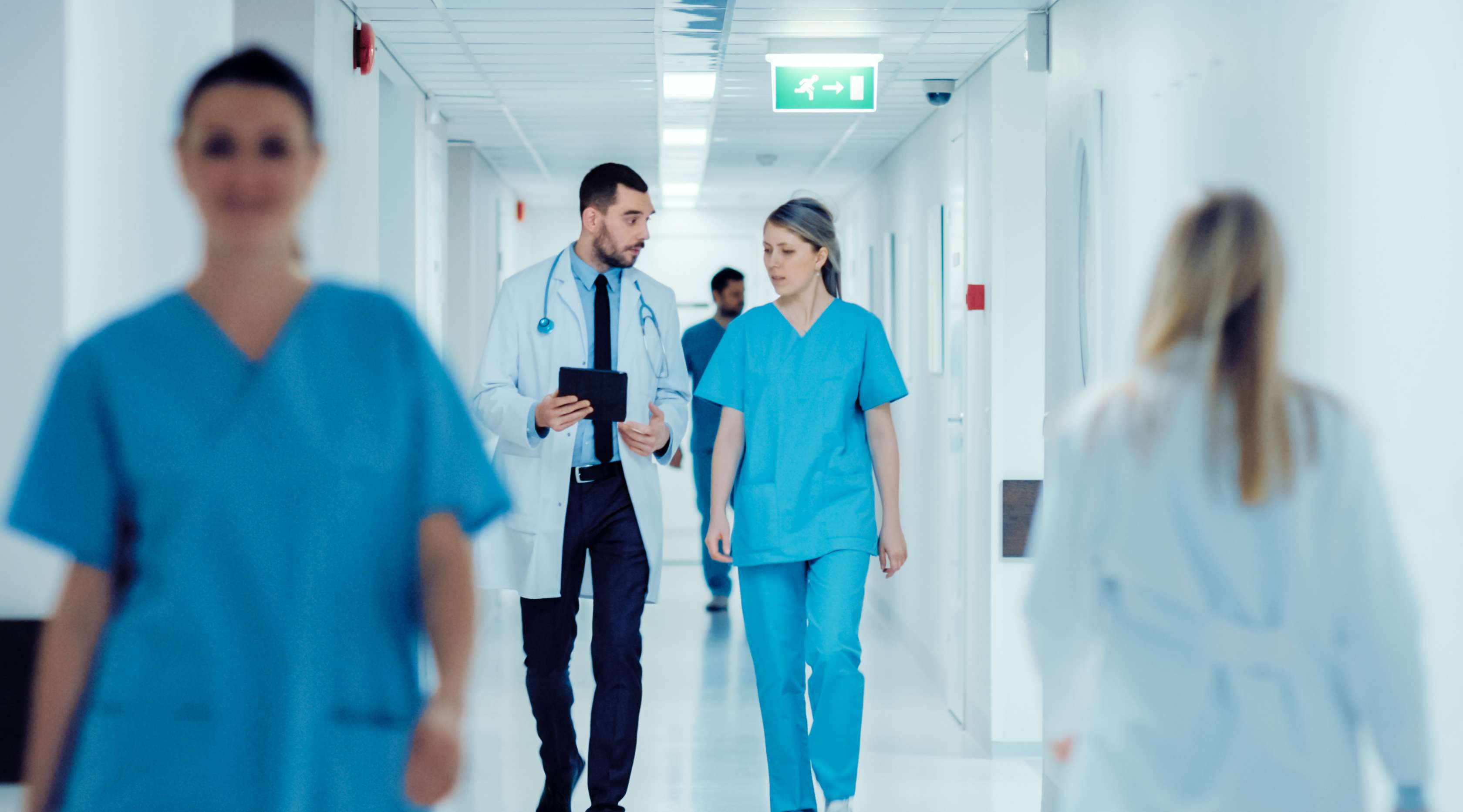Arzt mit Krankenschwester läuft einen Klinikflur entlang