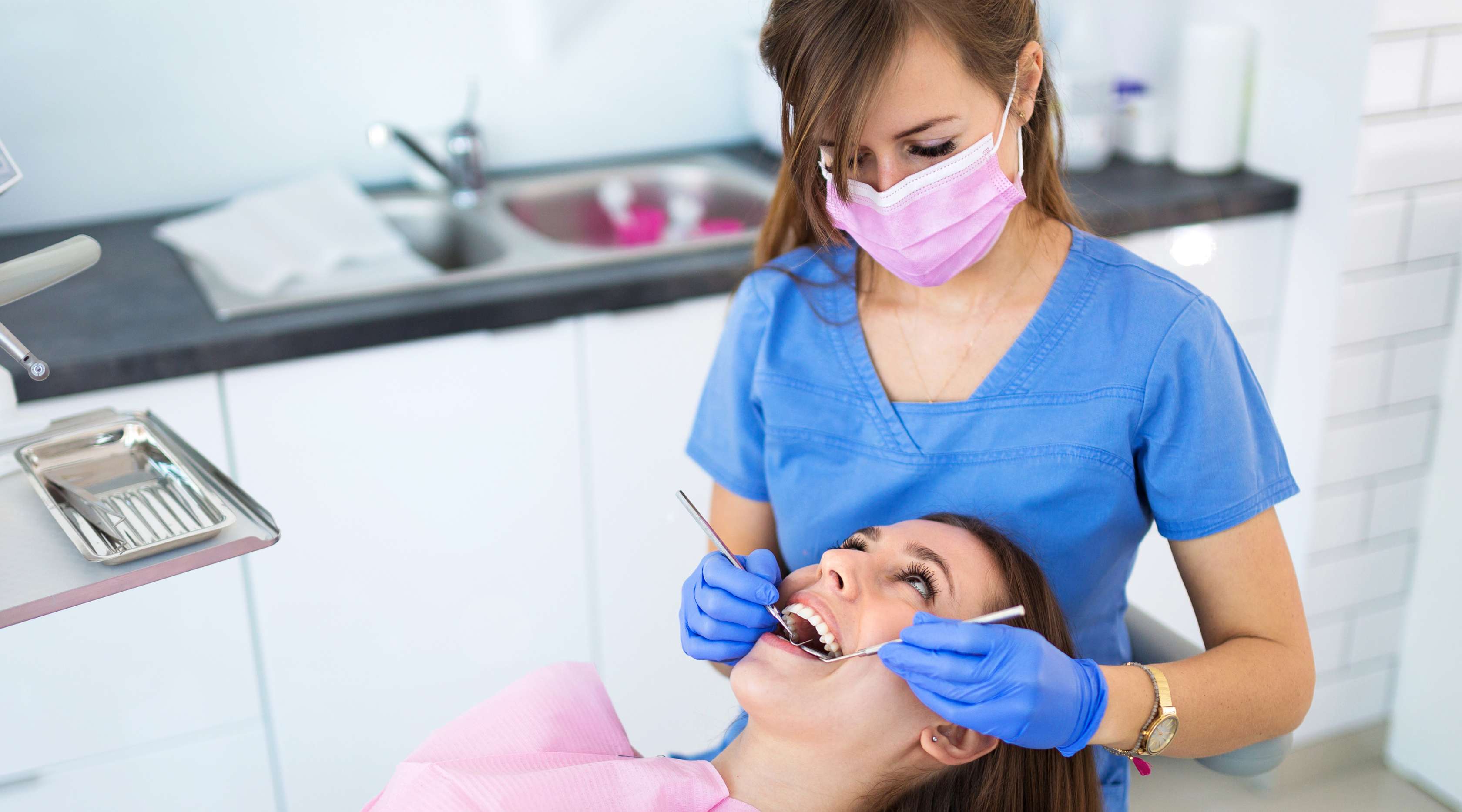 Zahnärztin kontrolliert die Zähne einer Patientin