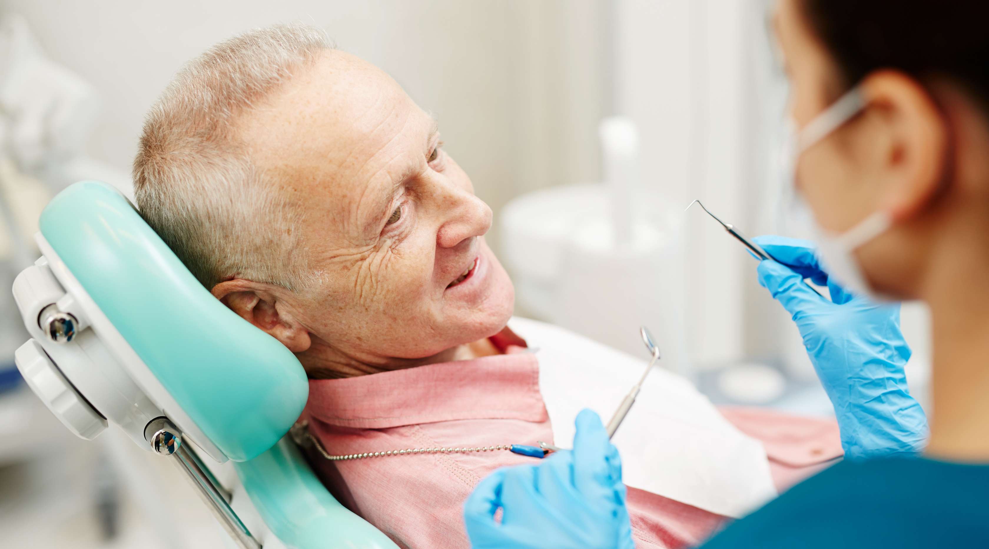 Älterer Mann sitzt auf einem Zahnarztstuhl