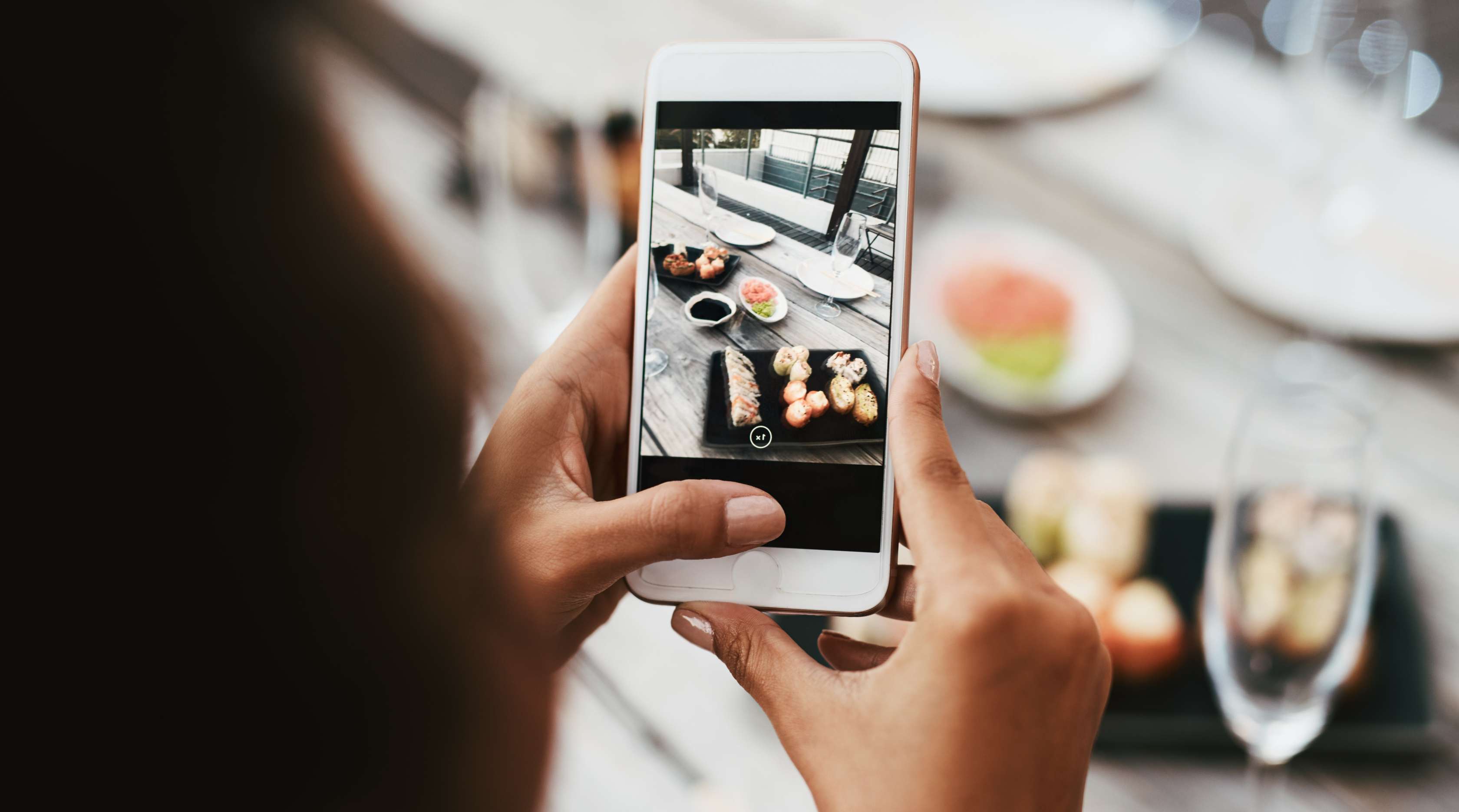 Frau fotografiert Essen mit einem Smartphone