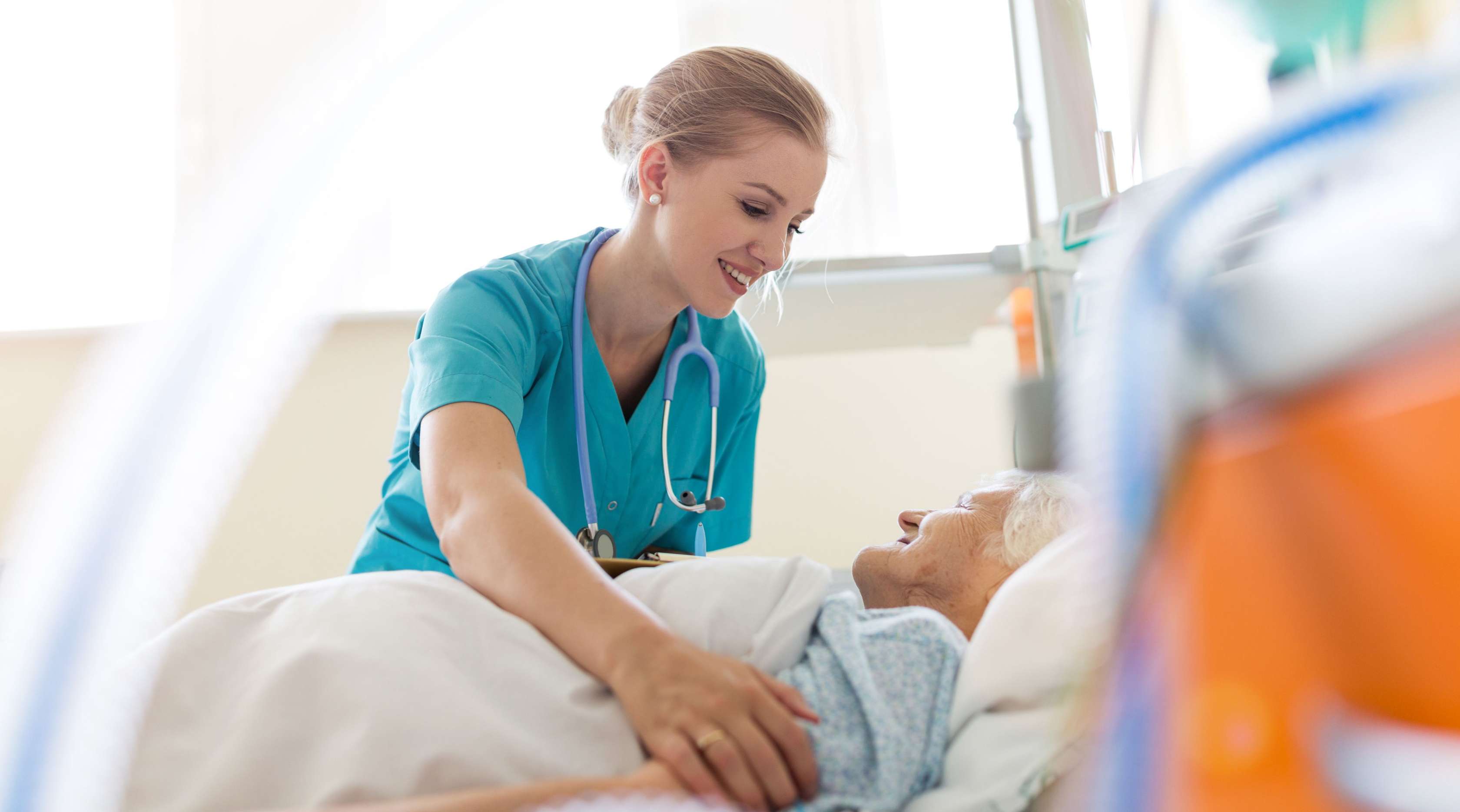 Krankenschwester steht am Bett einer Patientin