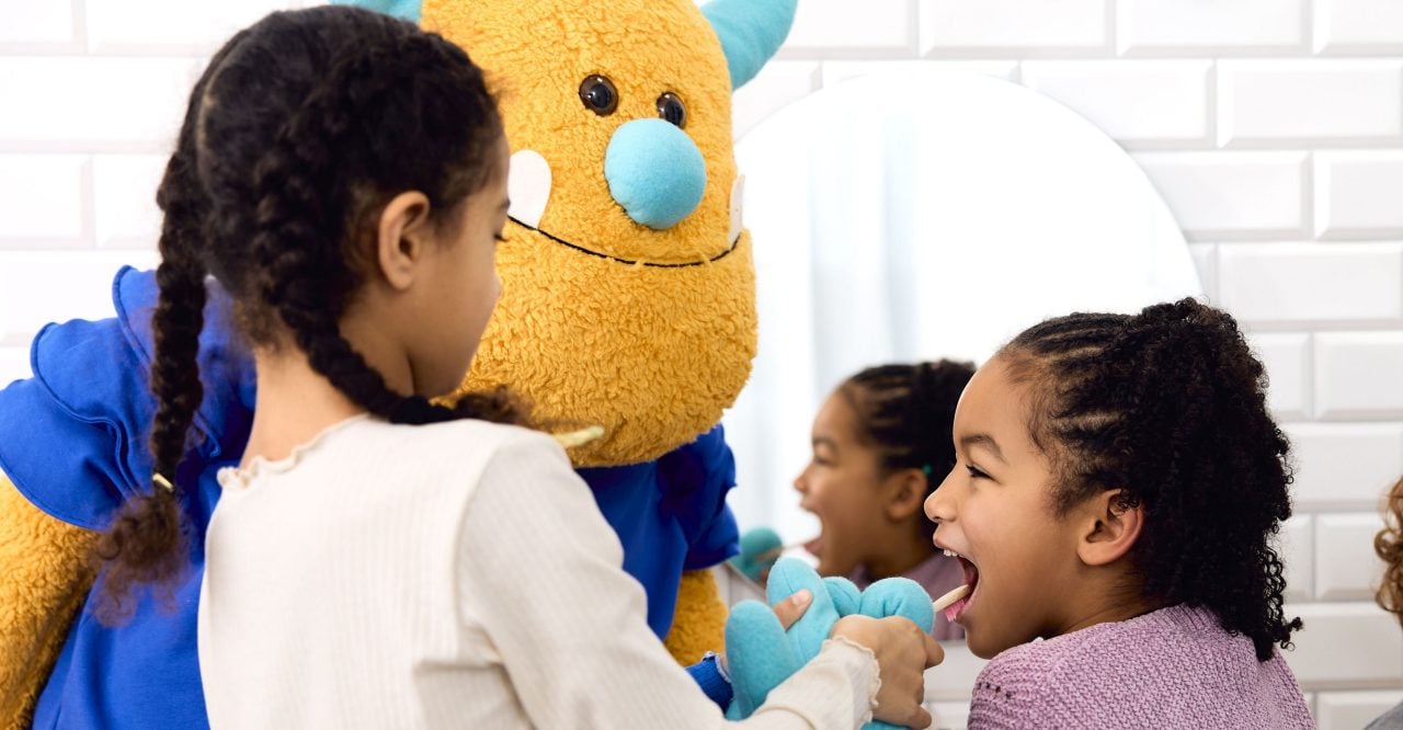 Zahnzusatzversicherung für Kinder: Kleine Kinder stehen im Bad und putzen sich die Zähne