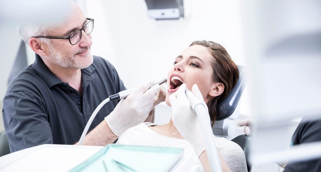 Zahnzusatzversicherung ohne Wartezeit: Ein Zahnarzt untersucht das Gebiss einer Patientin