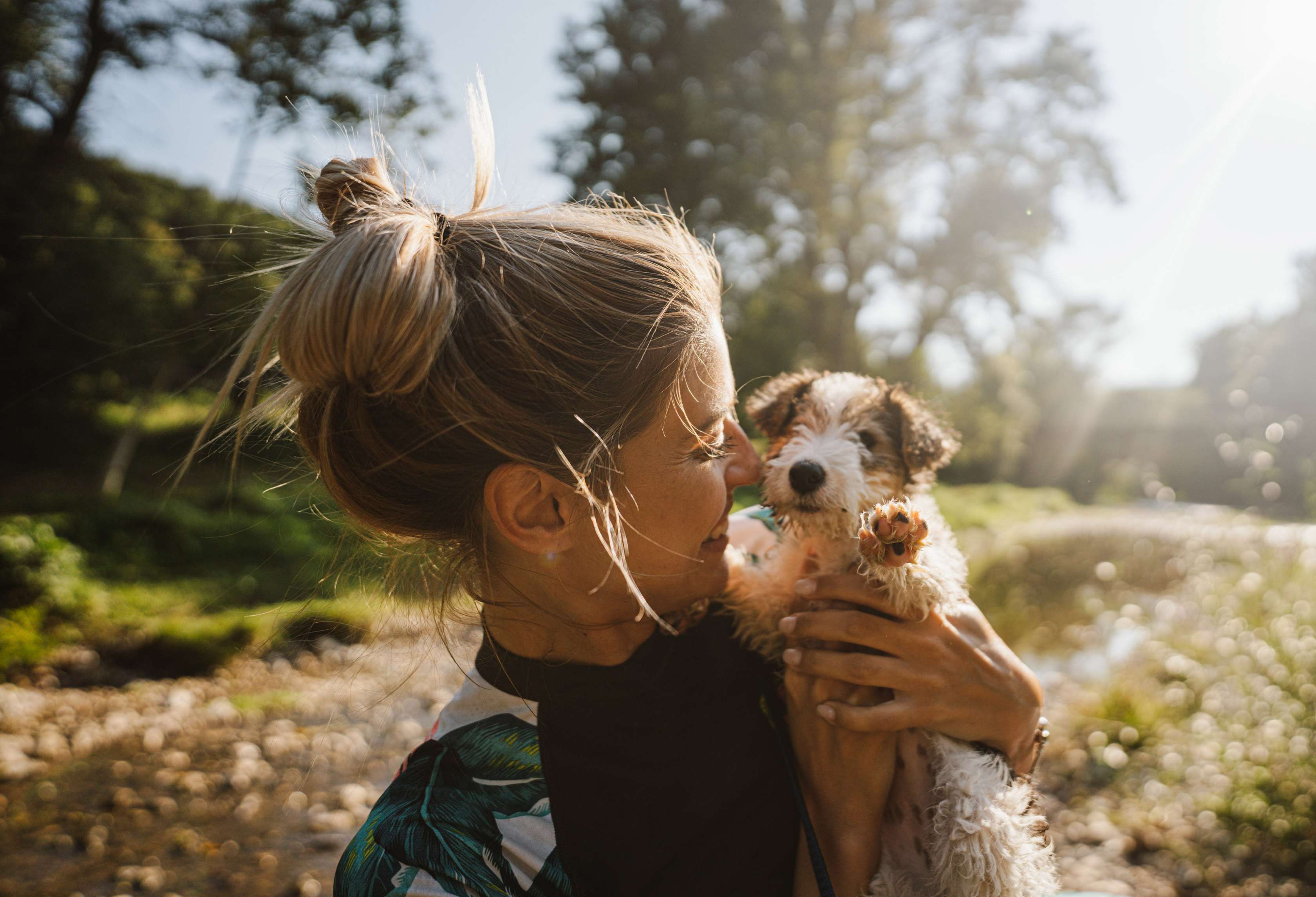 Hunde Kosten: Eine Frau hält einen jungen Hund auf dem Arm