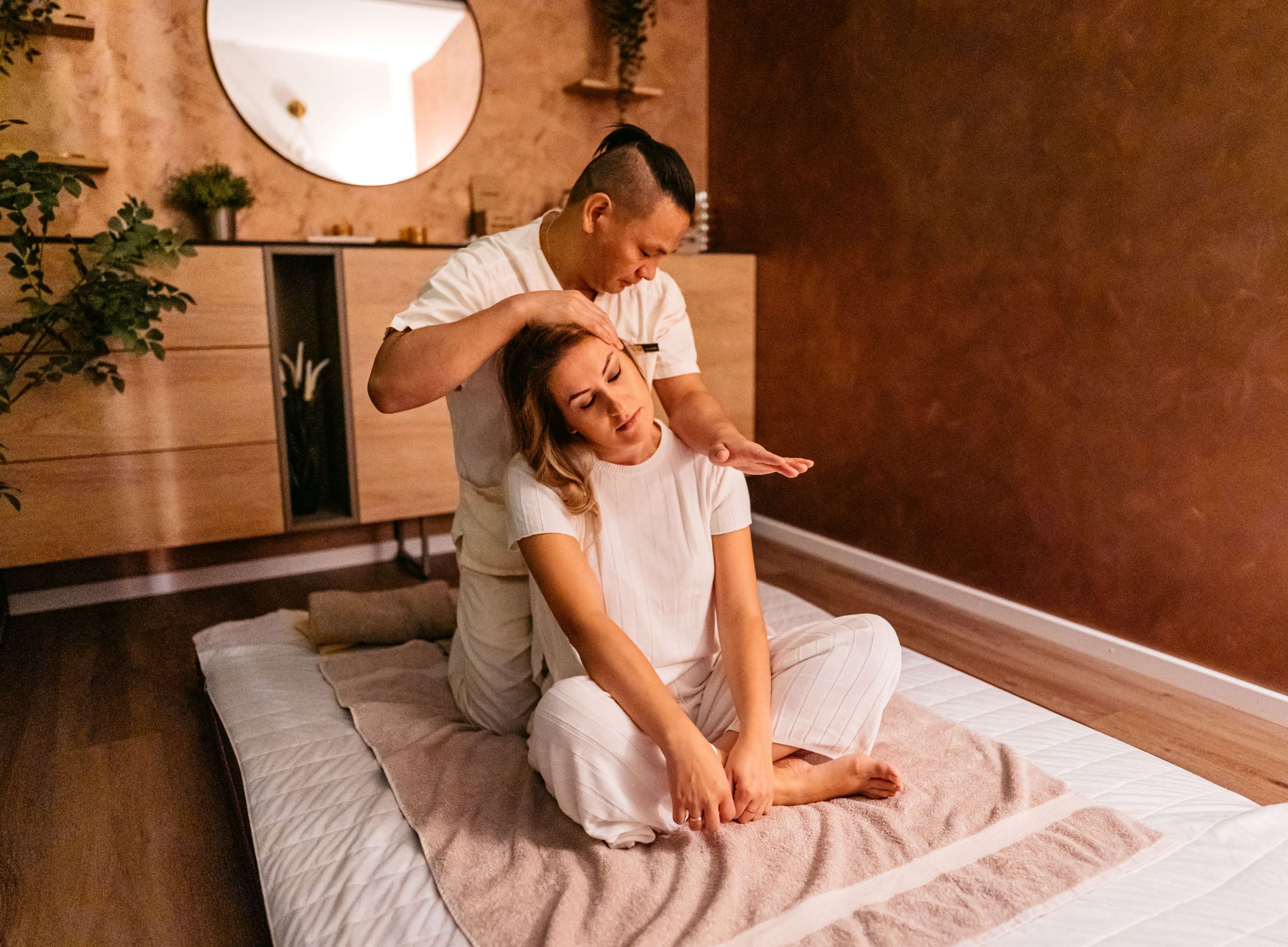 Allianz Ambulante Zusatz­versicherung: Ein Chiropraktiker renkt einer Frau den Nacken ein.