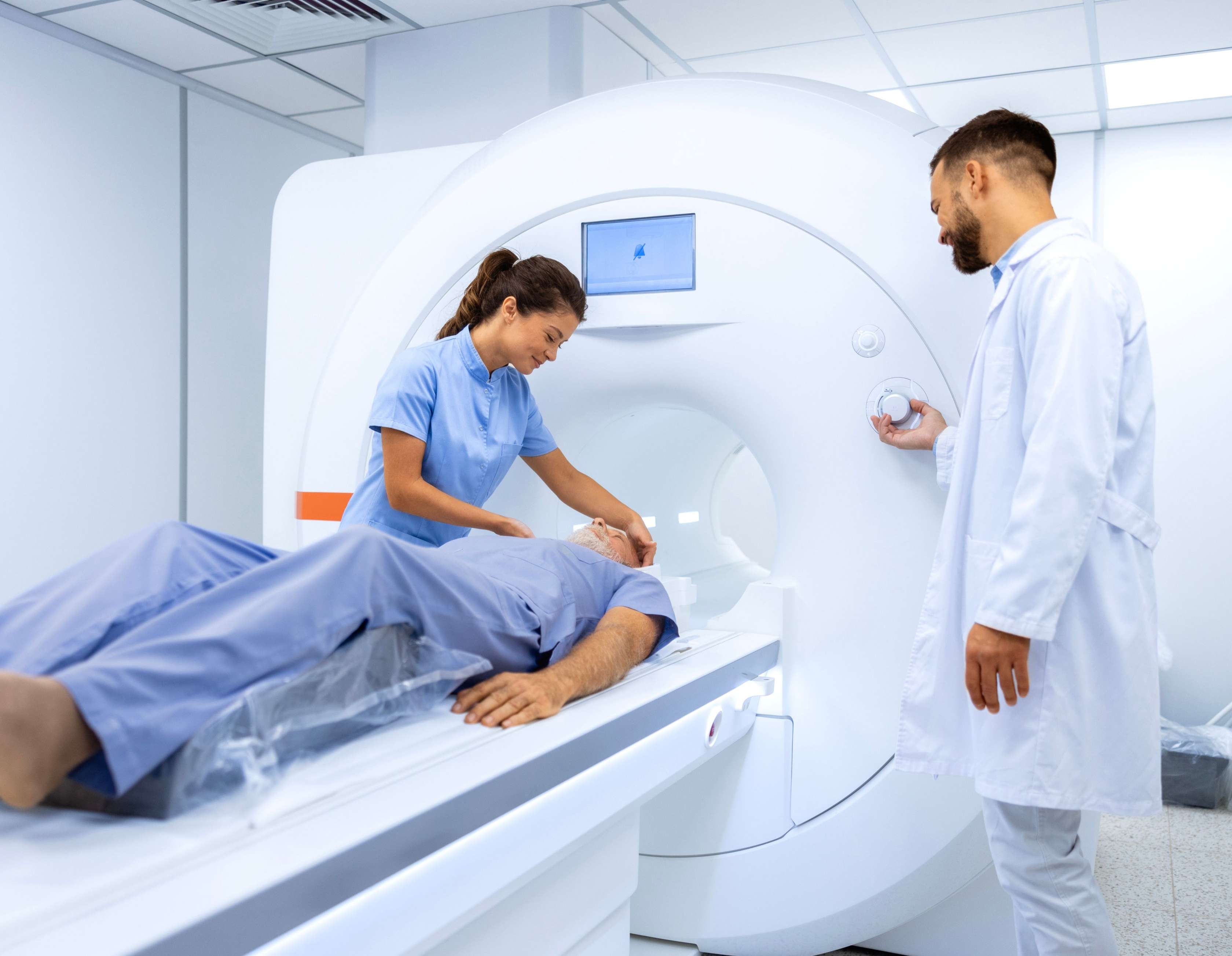 Allianz Krankenhauszusatzversicherung bei Vorerkrankungen: Medizinisches Personal bereitet einen Mann auf eine Untersuchung im MRT vor.