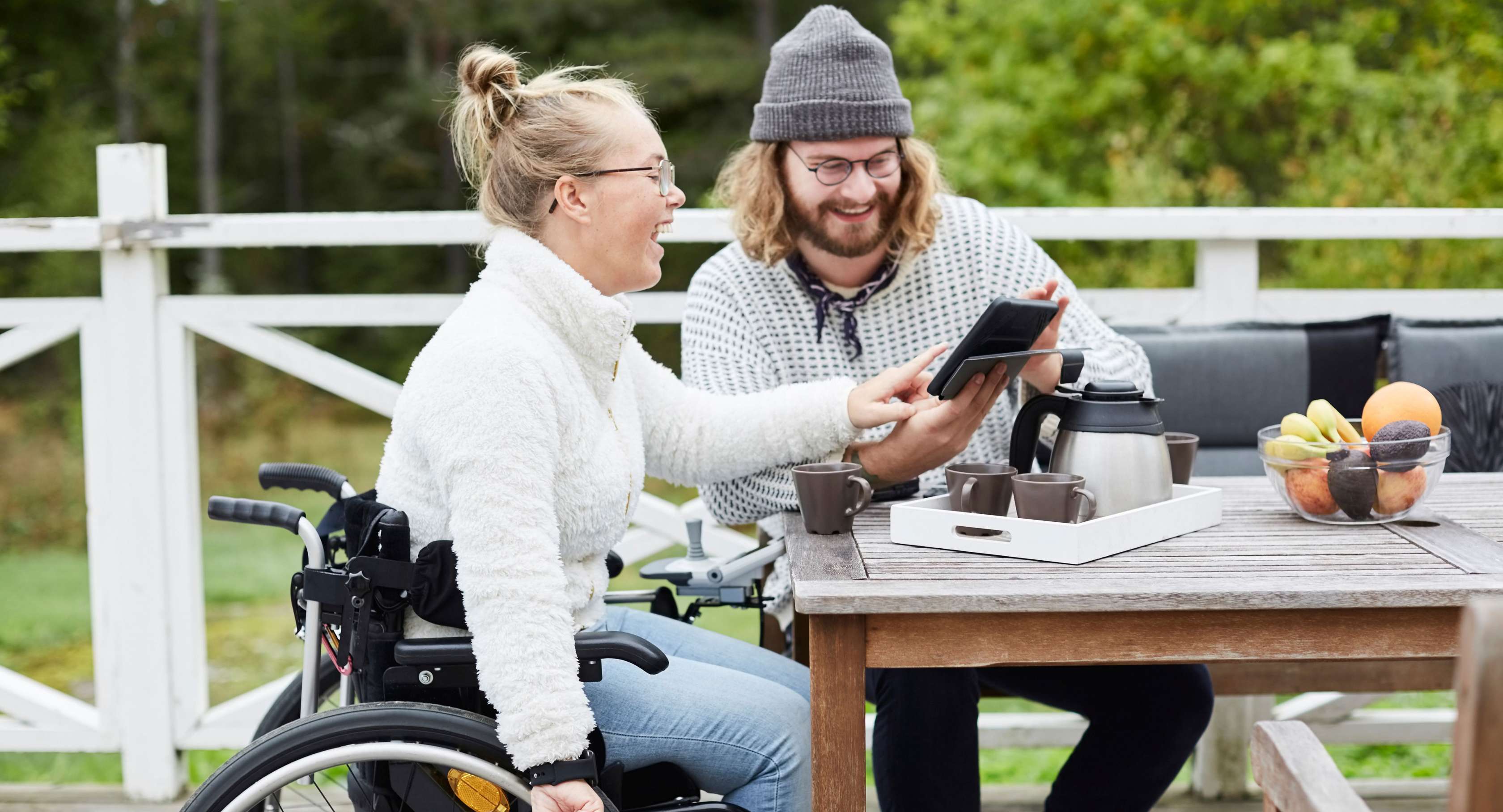 Junge Frau im Rollstuhl mit Mann auf der Terrasse
